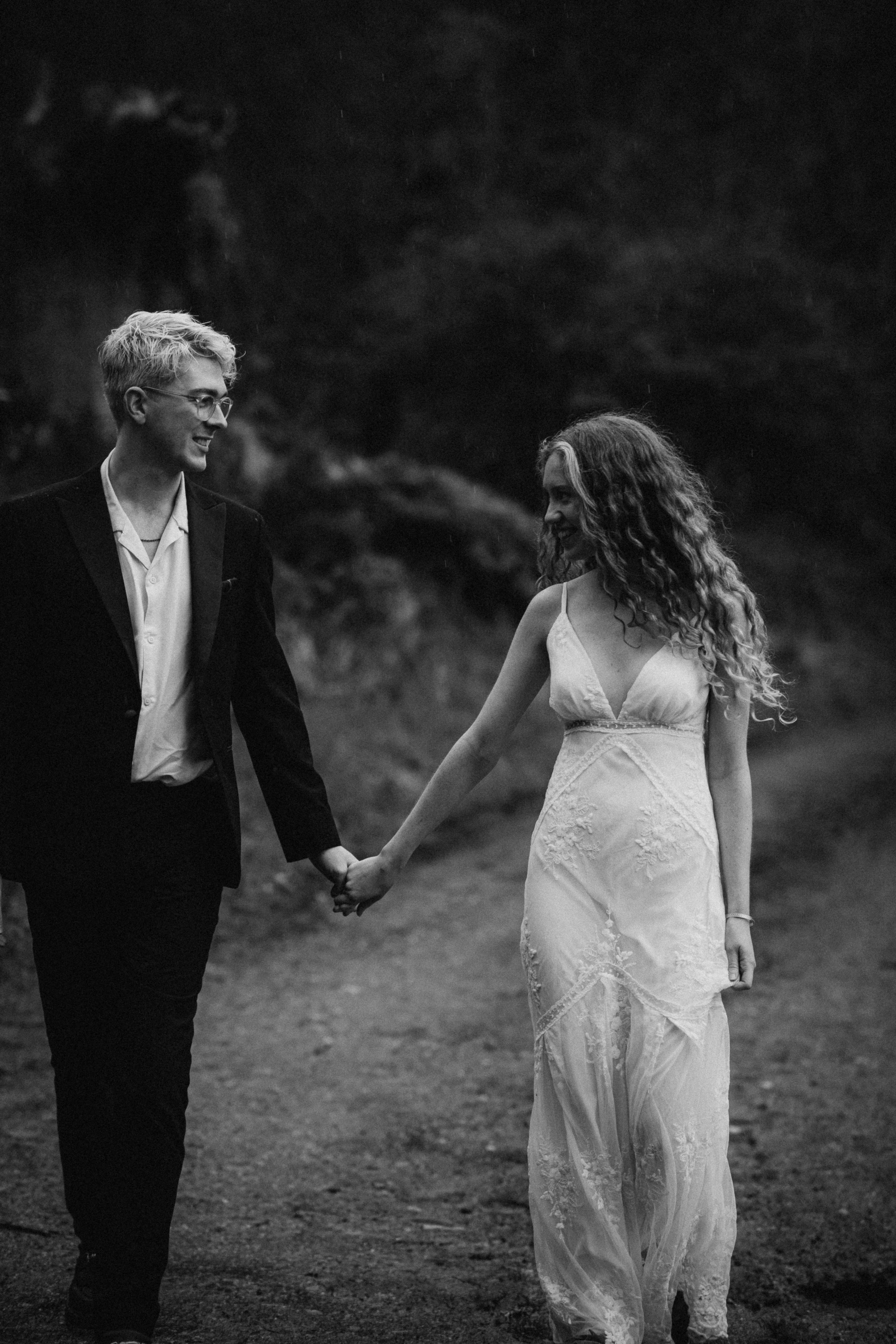 black and white picture of the couple in the woods walking