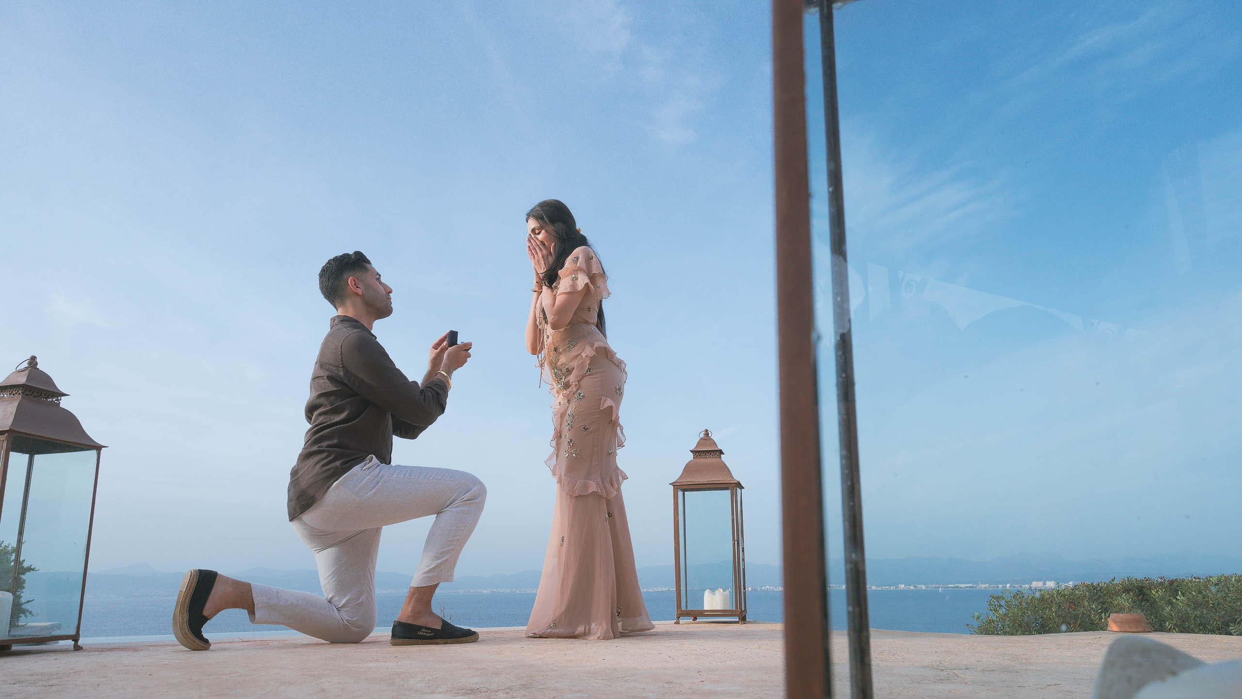 Knee on the ground, ring in his hand, Mediterranean sea behind and a top wedding proposal.