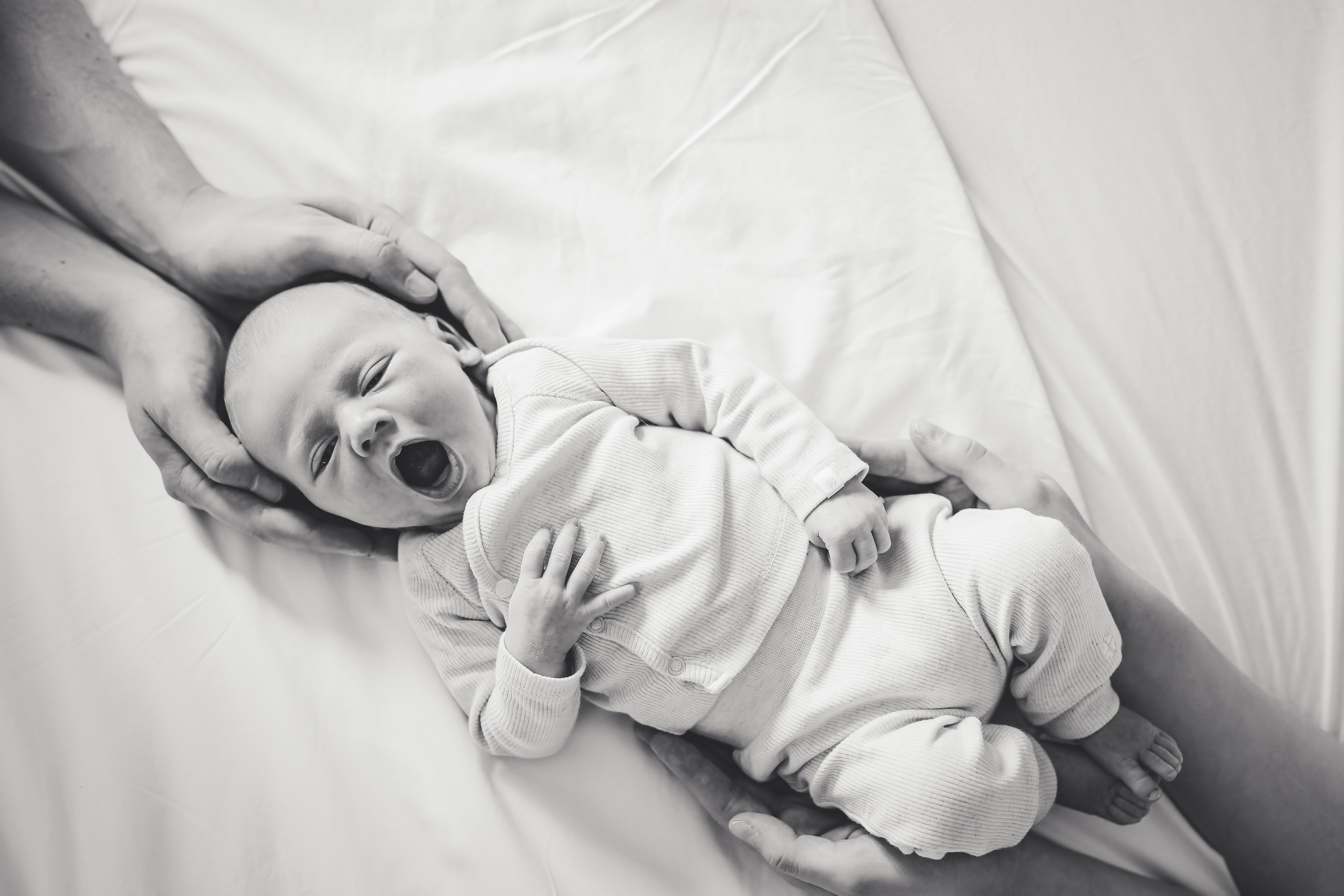 Sweet newborn baby snuggled up on the bed