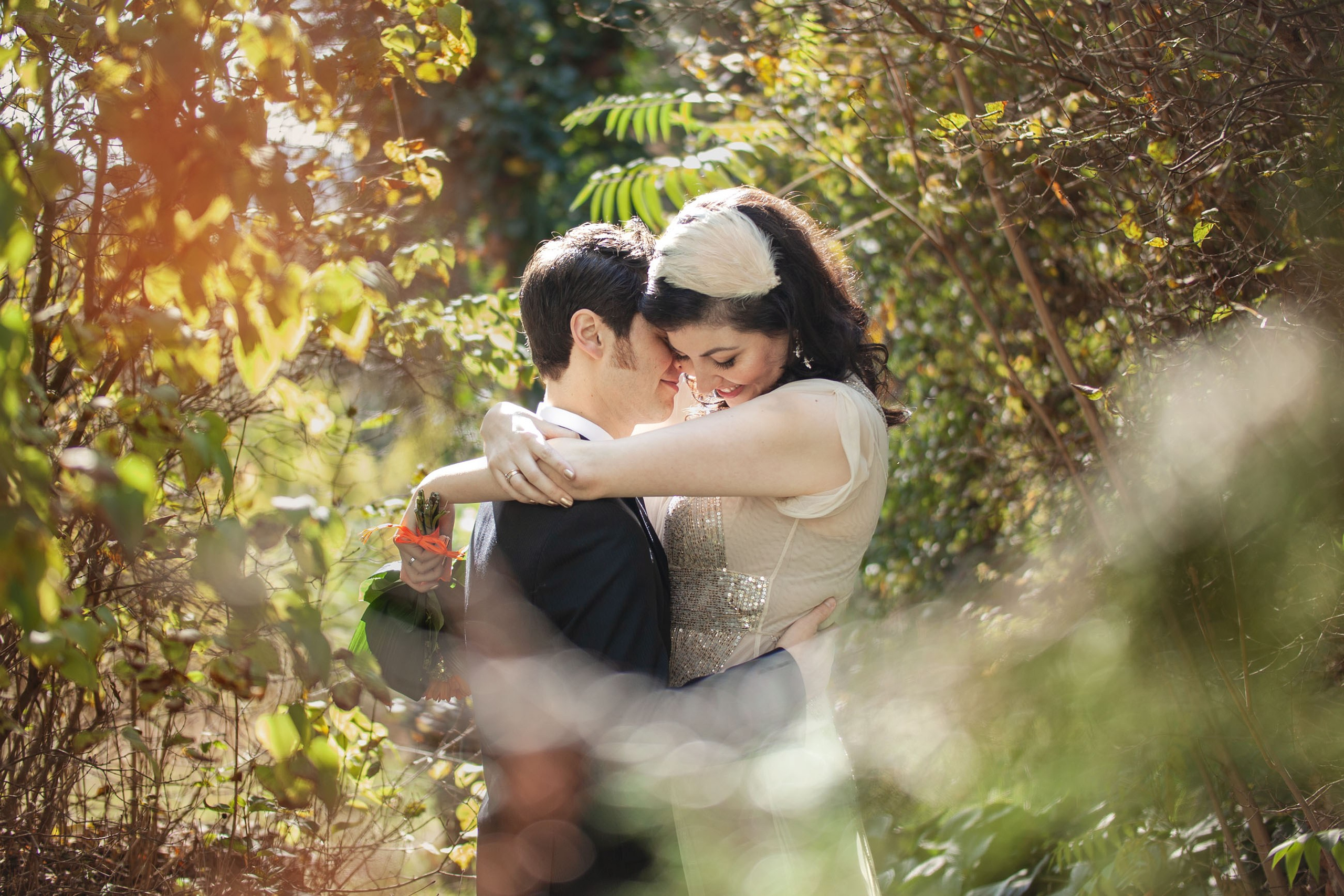 A brown-haired Canadian bride and her husband embrace in the lush forest setting above Prague. 