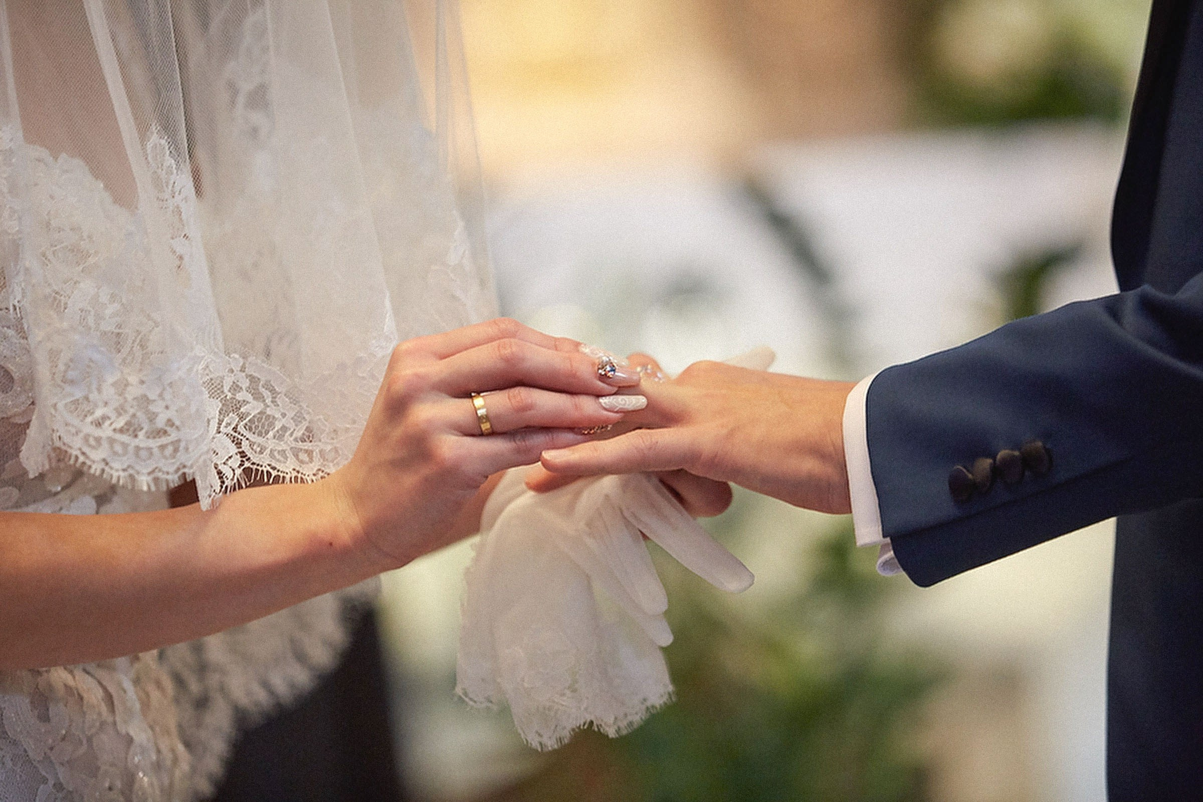 Young Japanese bride places ring on groom's finger at St. Martin's Parish Church, Bled, Slovenia.