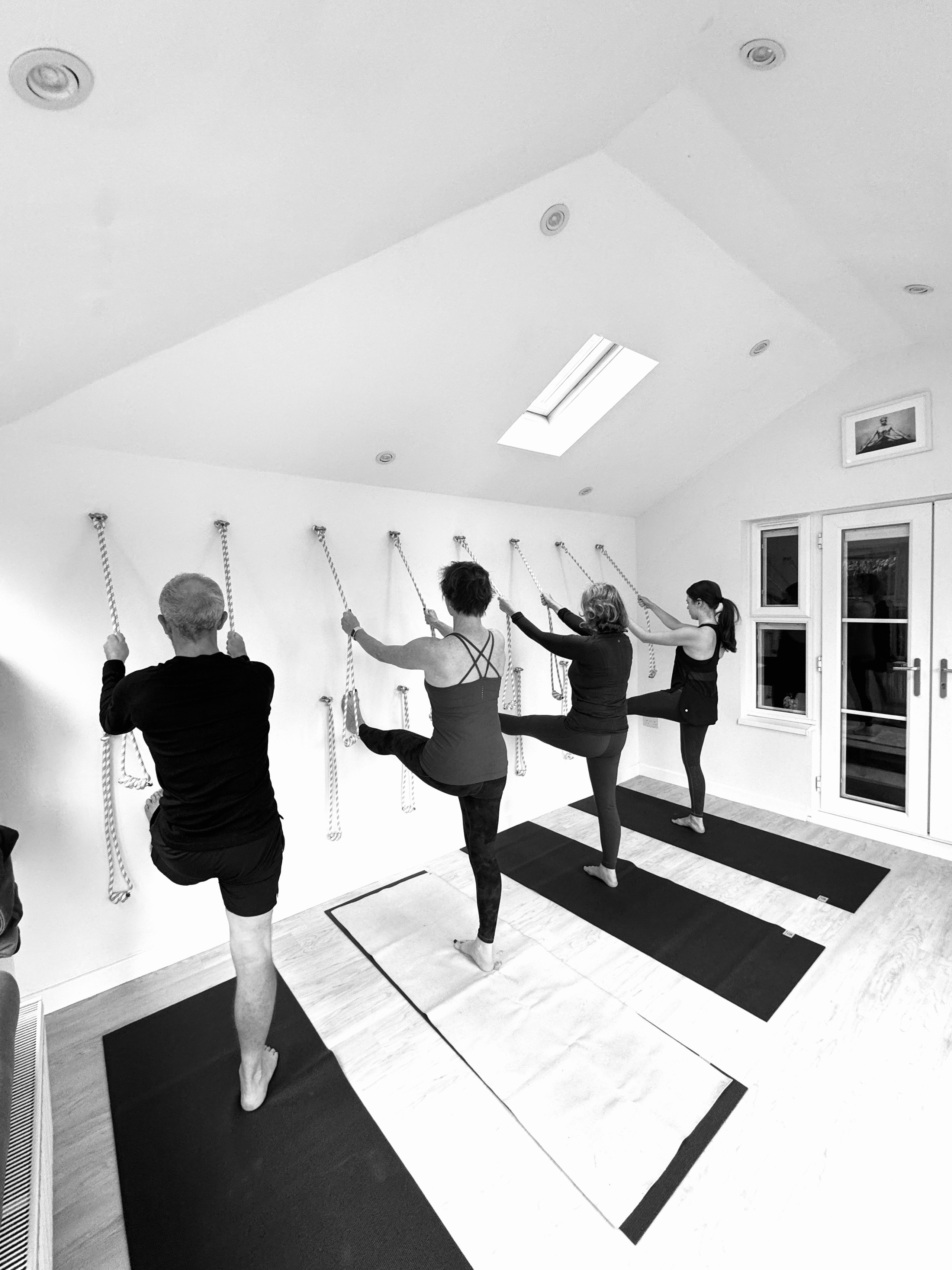 Relaxed and attentive small Iyengar yoga class in Solihull, students learning alignment and balance.