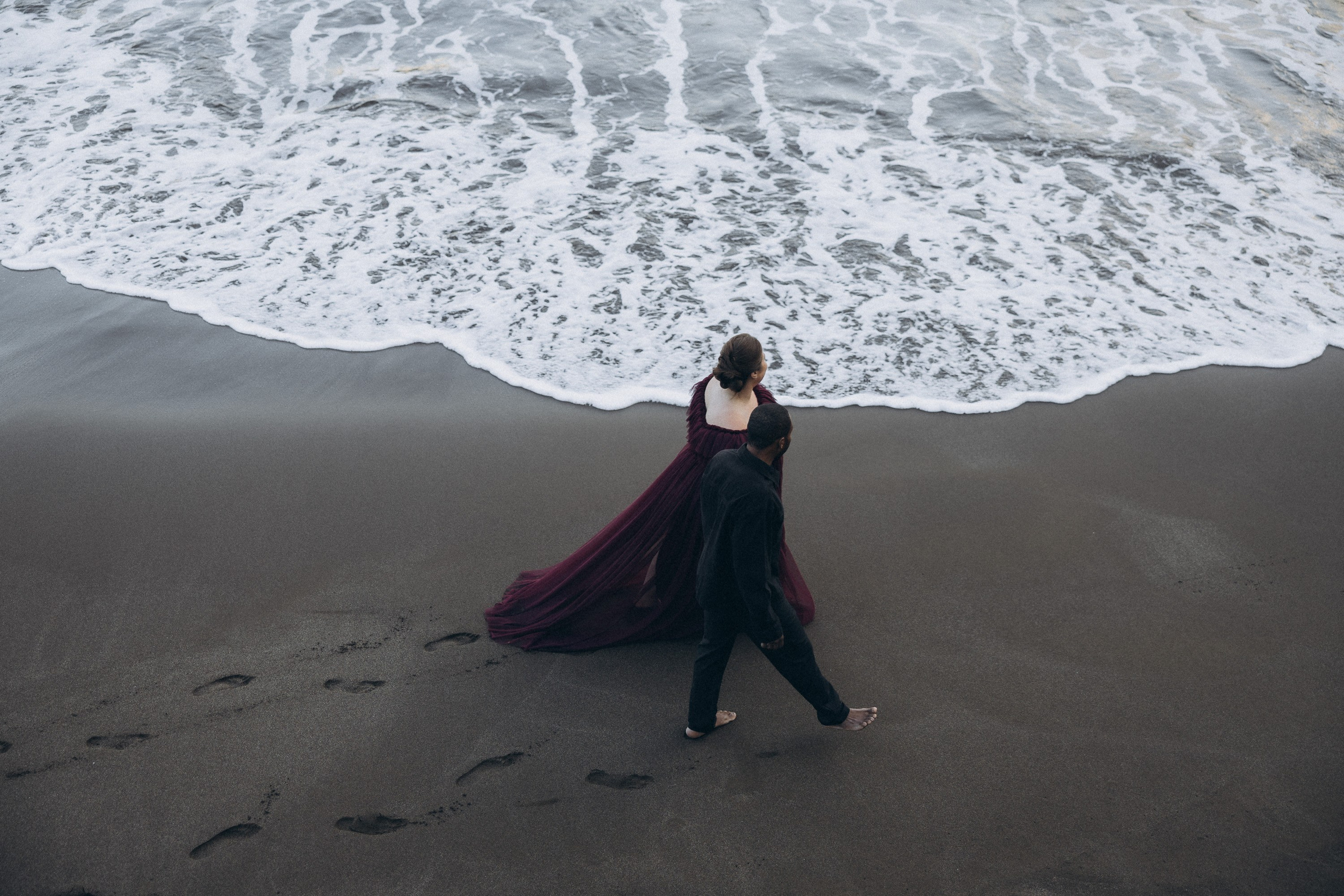 A glowing expectant mother standing on a cliff overlooking the ocean in Madeira, her dress flowing gently in the wind as the golden sunset casts a warm glow.