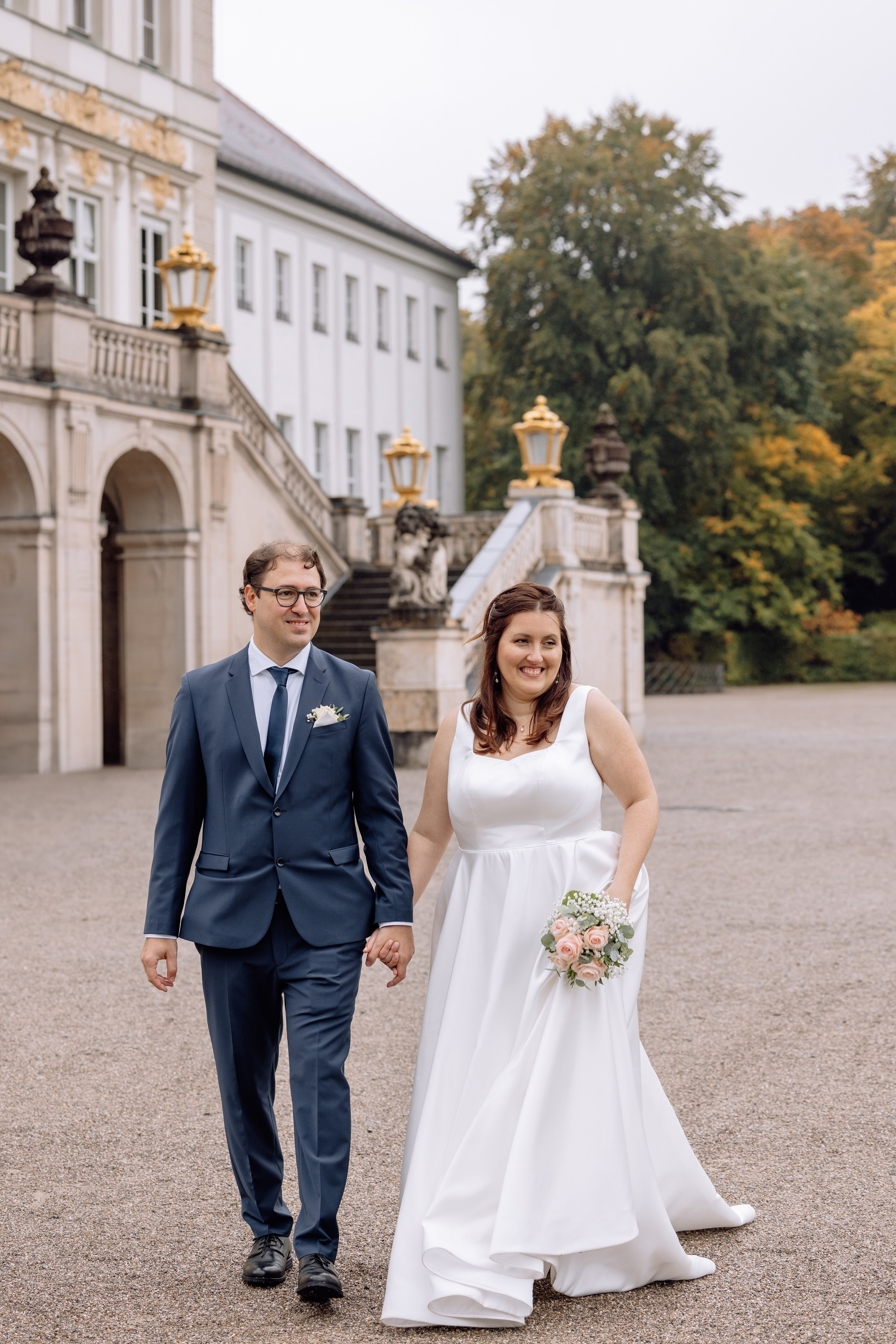 Paar spaziert im Regen vor dem Schloss Nymphenburg