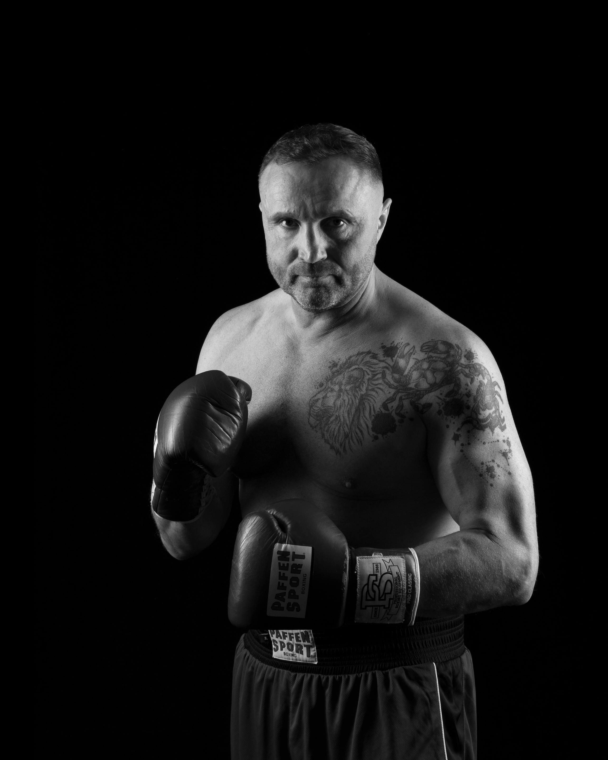 Studioaufnahme von Vitalii, Boxer, mit Konturlicht, das die Muskeln und Form betont