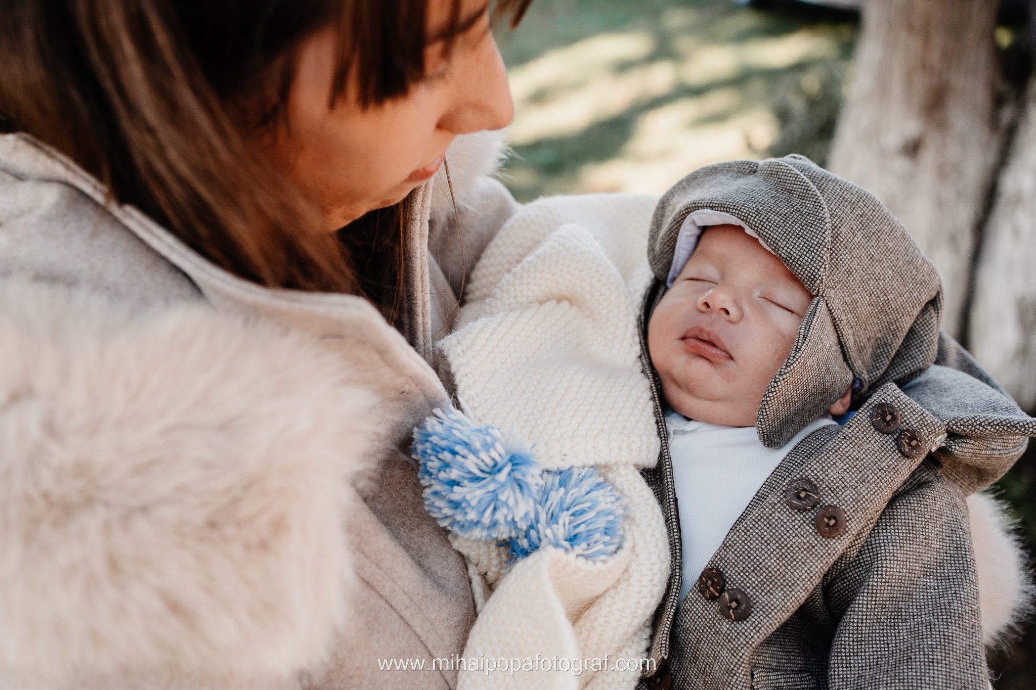 Instantaneu plin de tandrețe dintre părinți și bebeluș în ziua botezului, realizat în ilfov. Fotografie profesională de botez, capturând emoțiile autentice ale familiei într-un decor luminos și cald