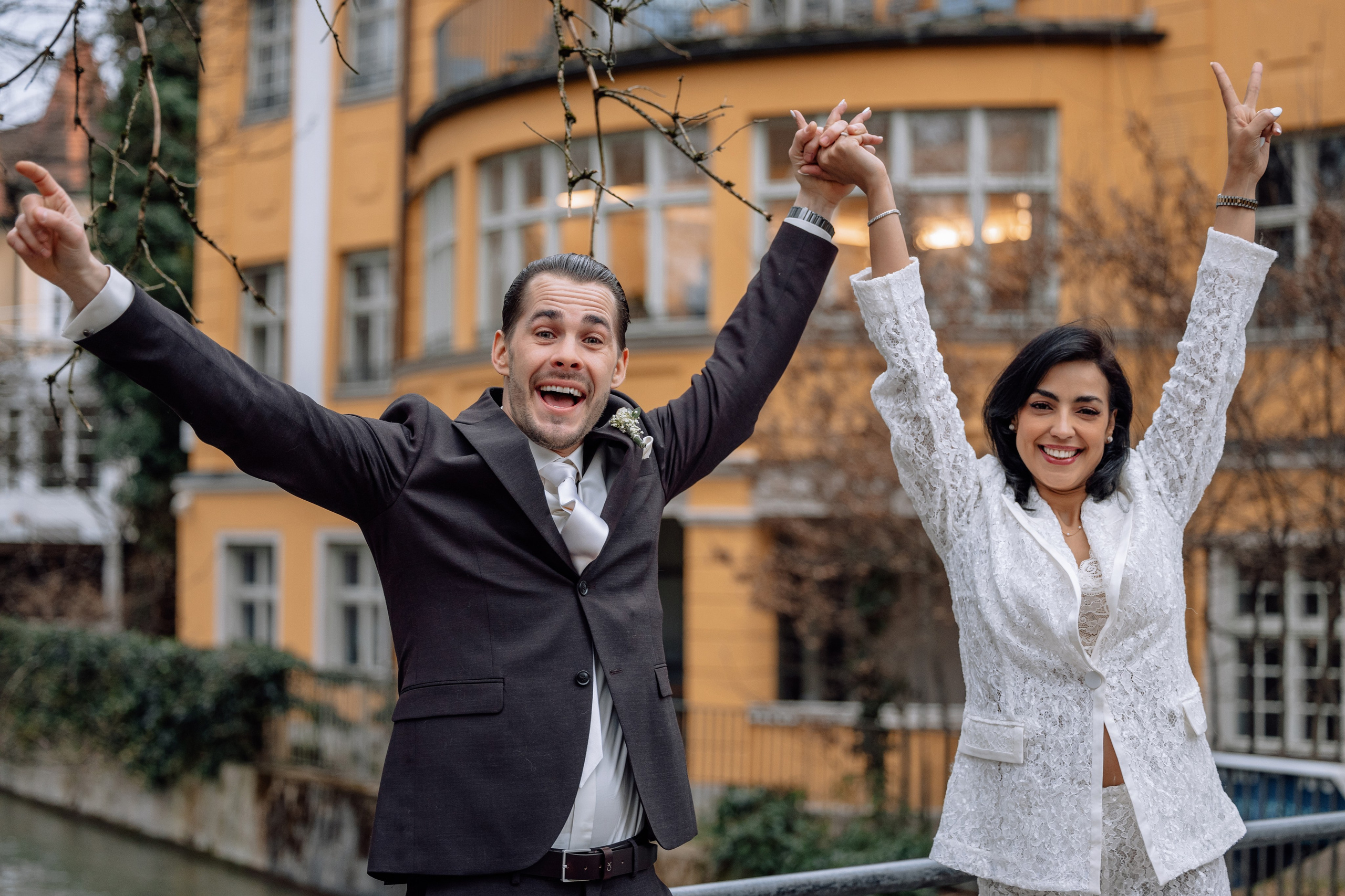 Brautpaar springt, hebt die Hände in die Luft – glücklicher Moment Mandlstraße 14