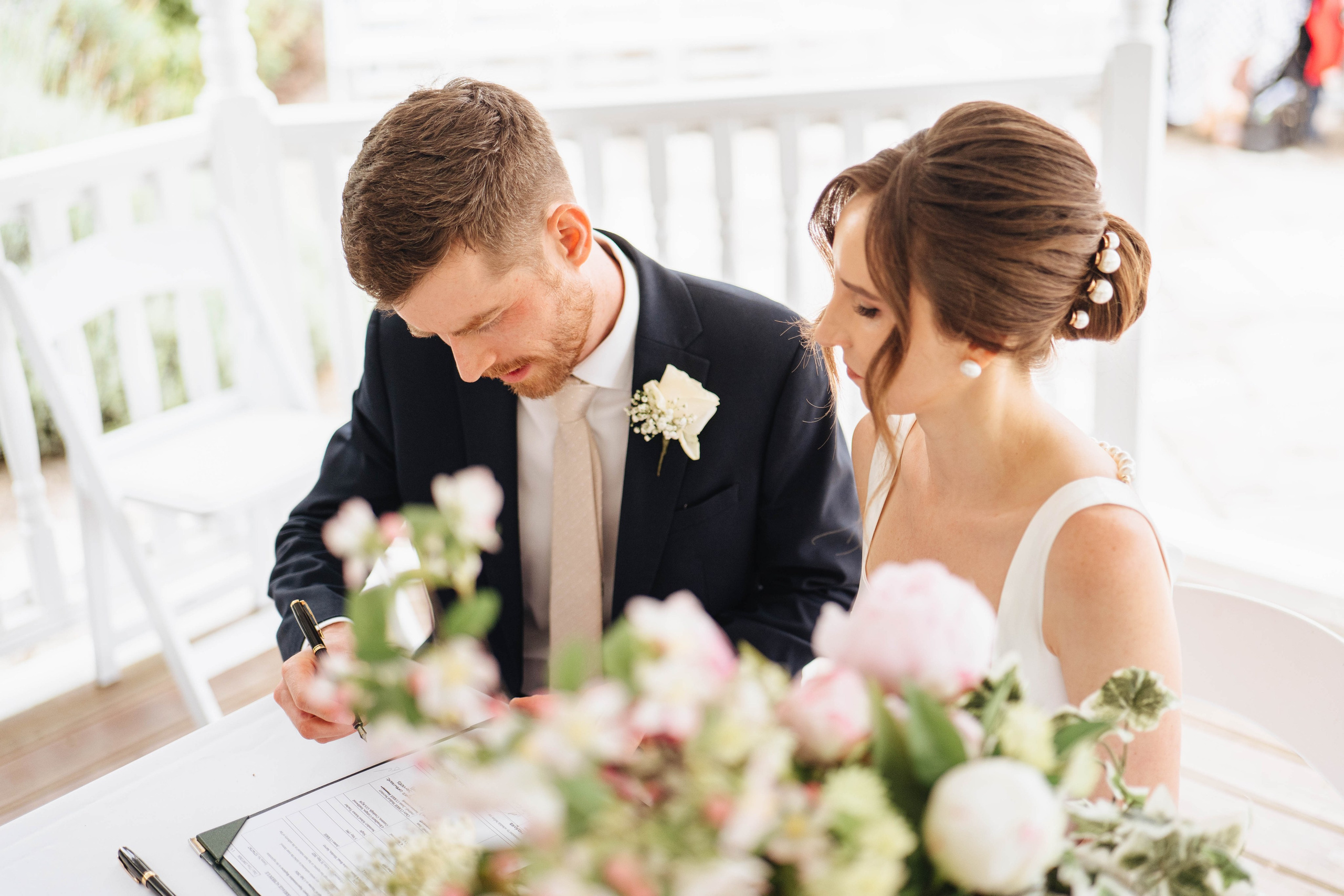 bride and groom signing papers at the wedding ceremony