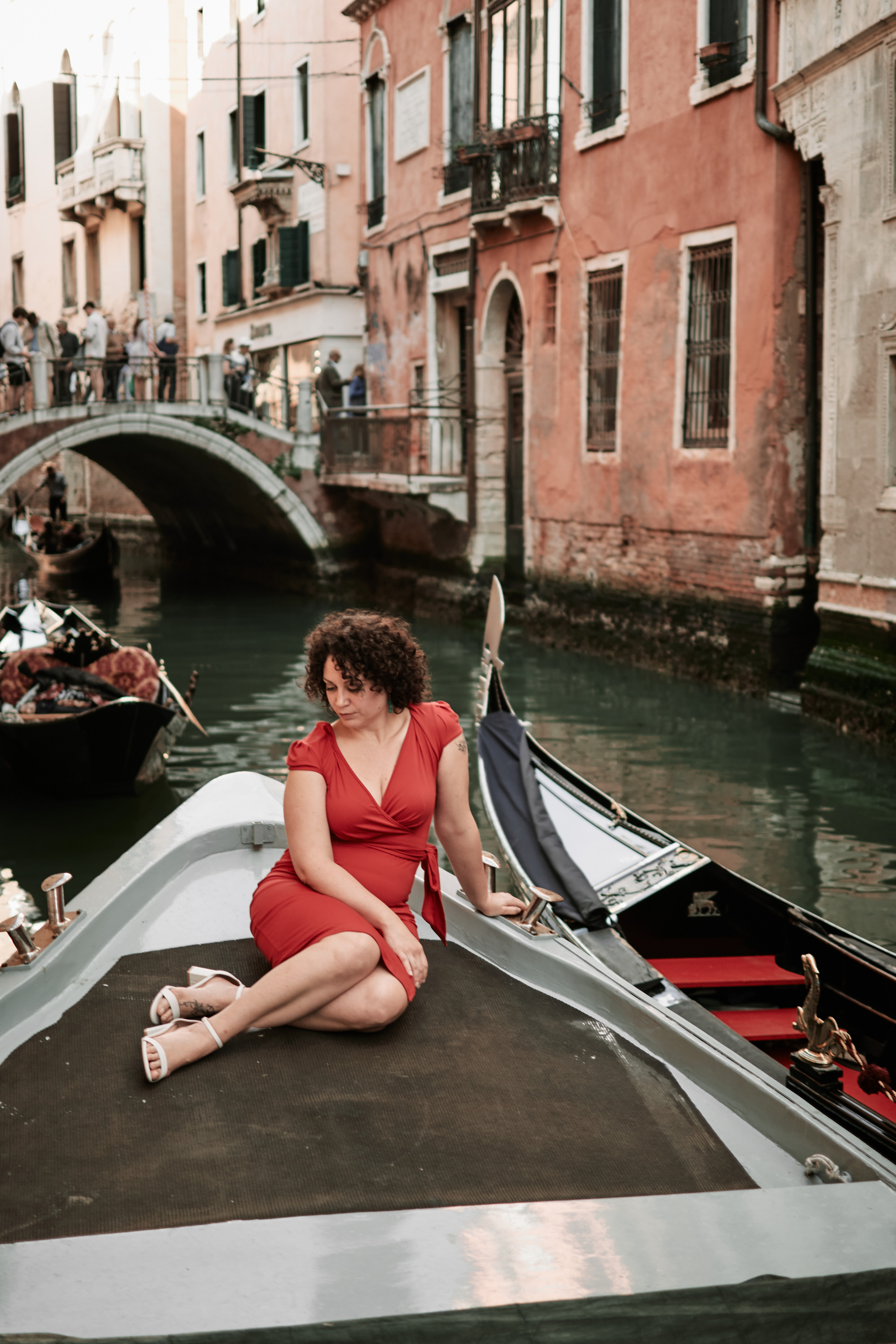 We started our photography session on a charming boat, gliding along the serene canals, as the golden light reflected on the water, creating a dreamy ambiance. The Italian girl's radiant smile matched the warmth of the setting sun, making every frame come alive with passion and allure.