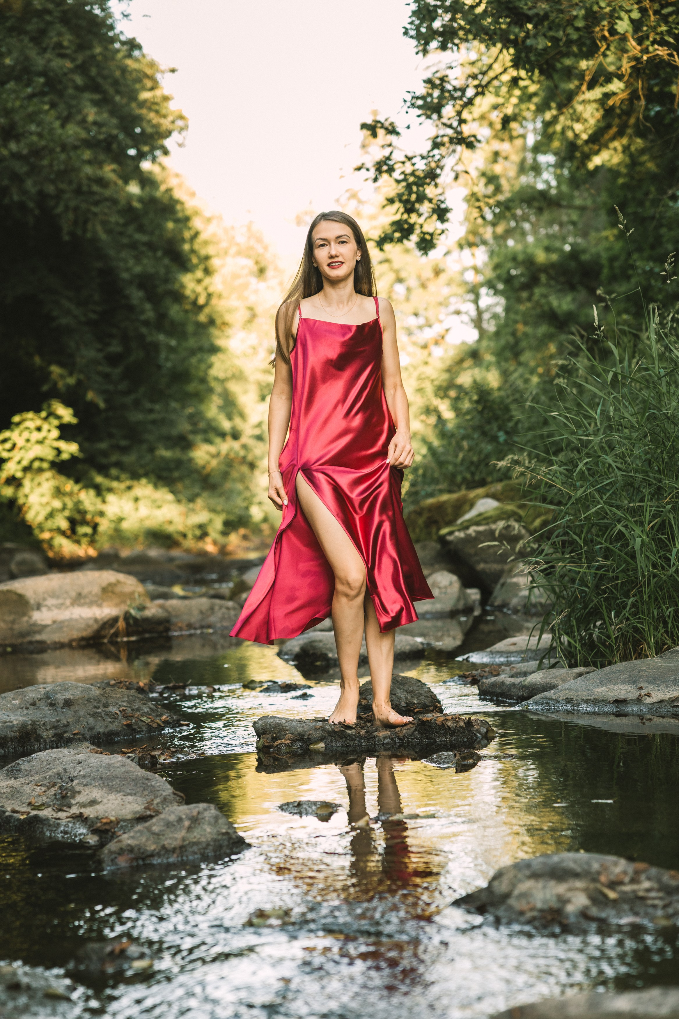 Portrétní focení u řeky — žena v červených šatech. Lifestyle a rodinná fotografka v Pisku Oxana Telupilova