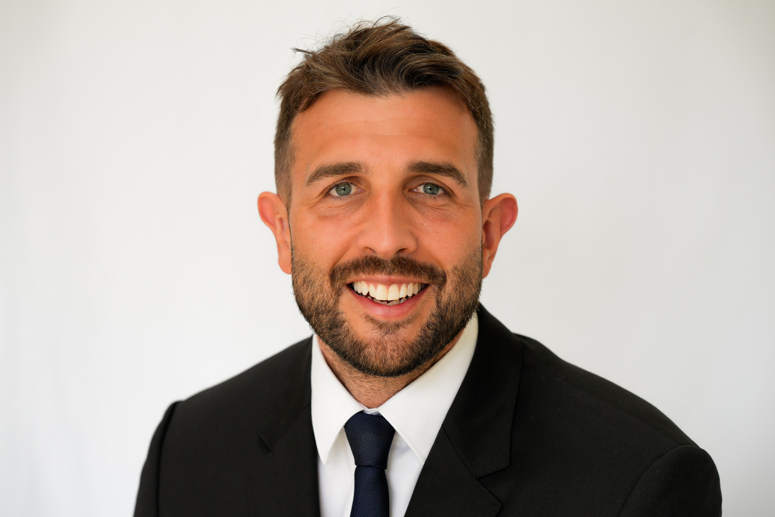 Elegant business portrait in Solihull of a man in a classic suit, posing with a subtle smile