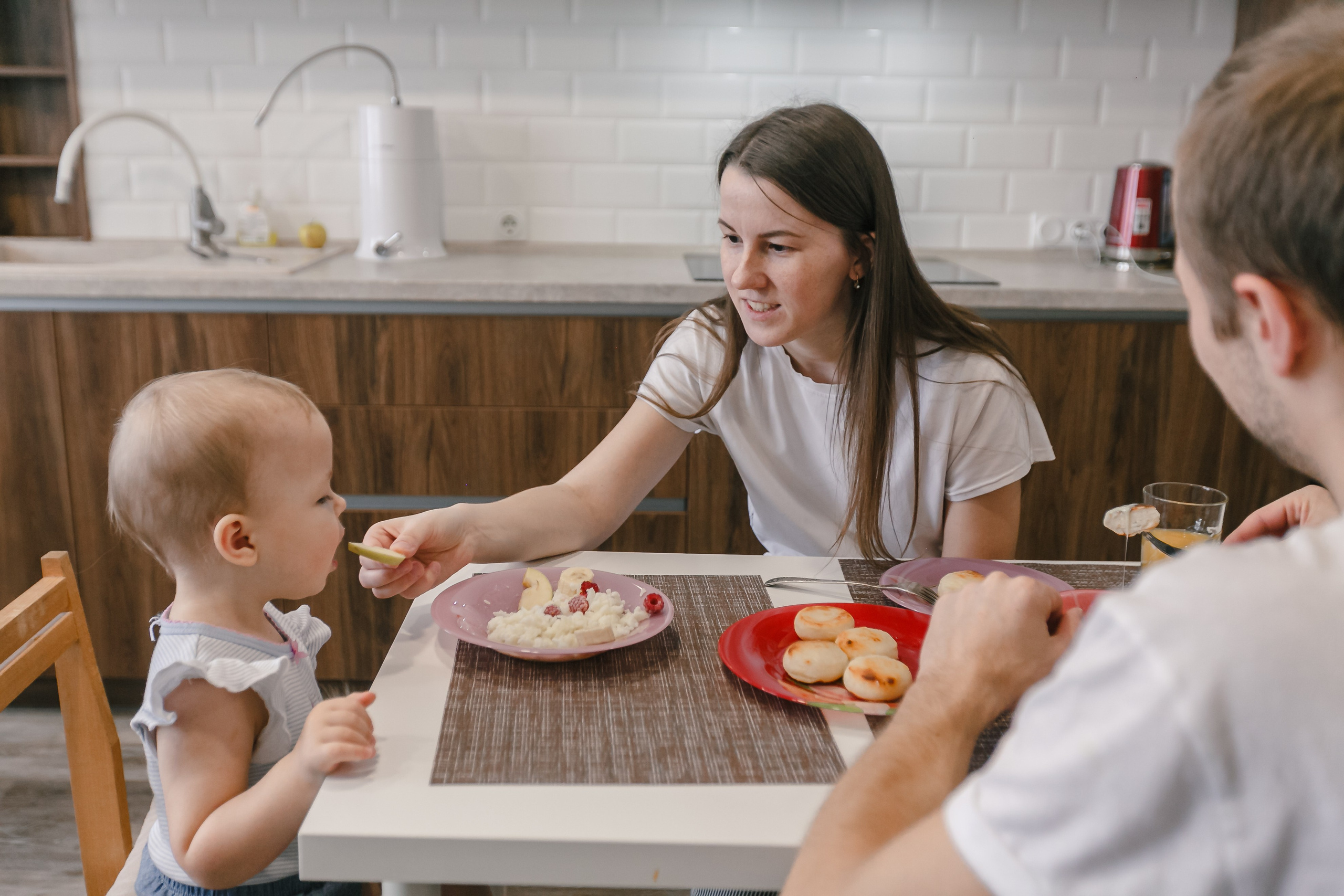 Mamá, papá e hija preparando juntos el desayuno en casa. Fotógrafo de retrato, familia y reportajes en Valencia | España | Europa Vitalii Lumier