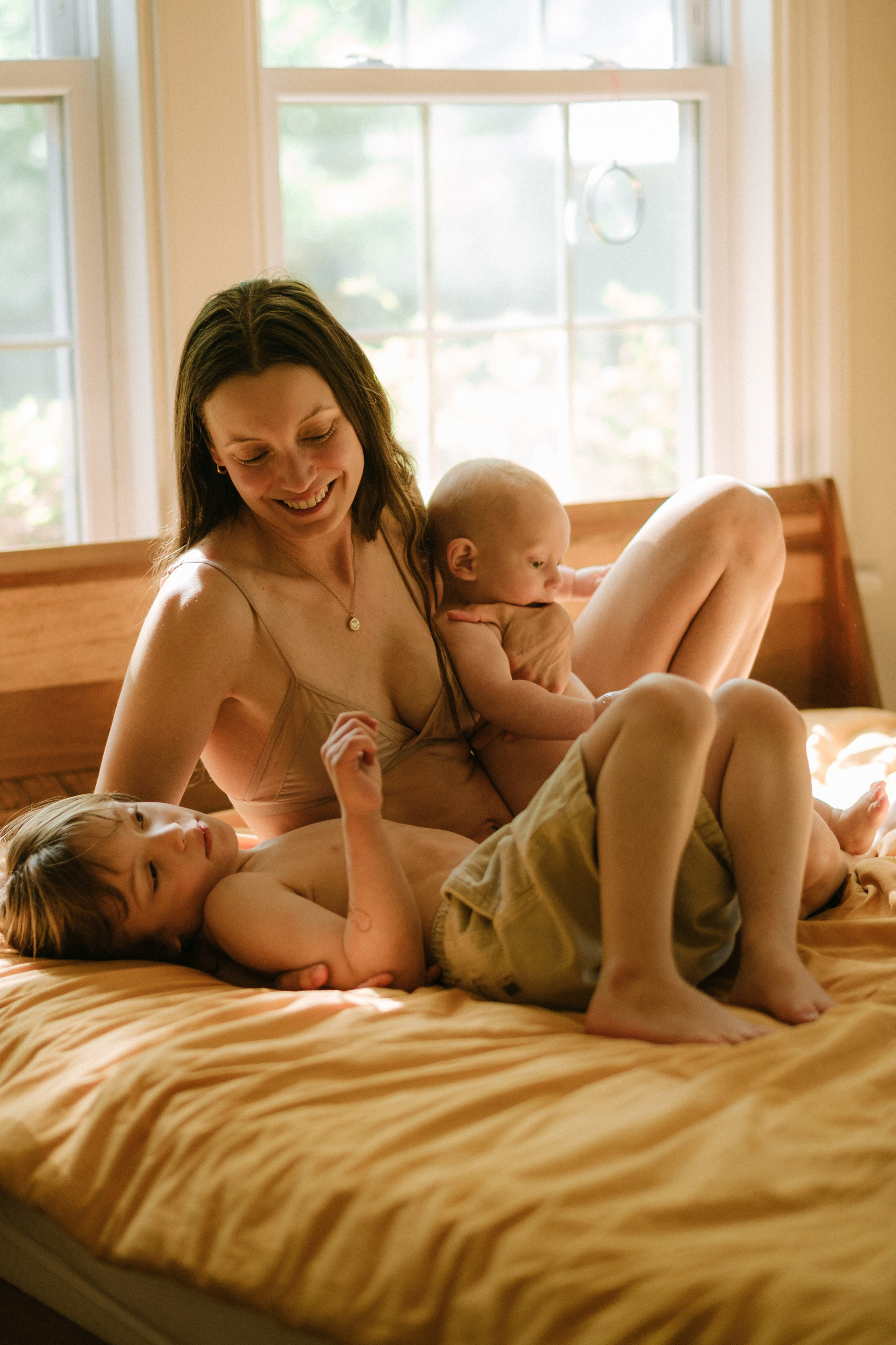 Mother lying in the bed with two her sons during a family session in Richmond, VA