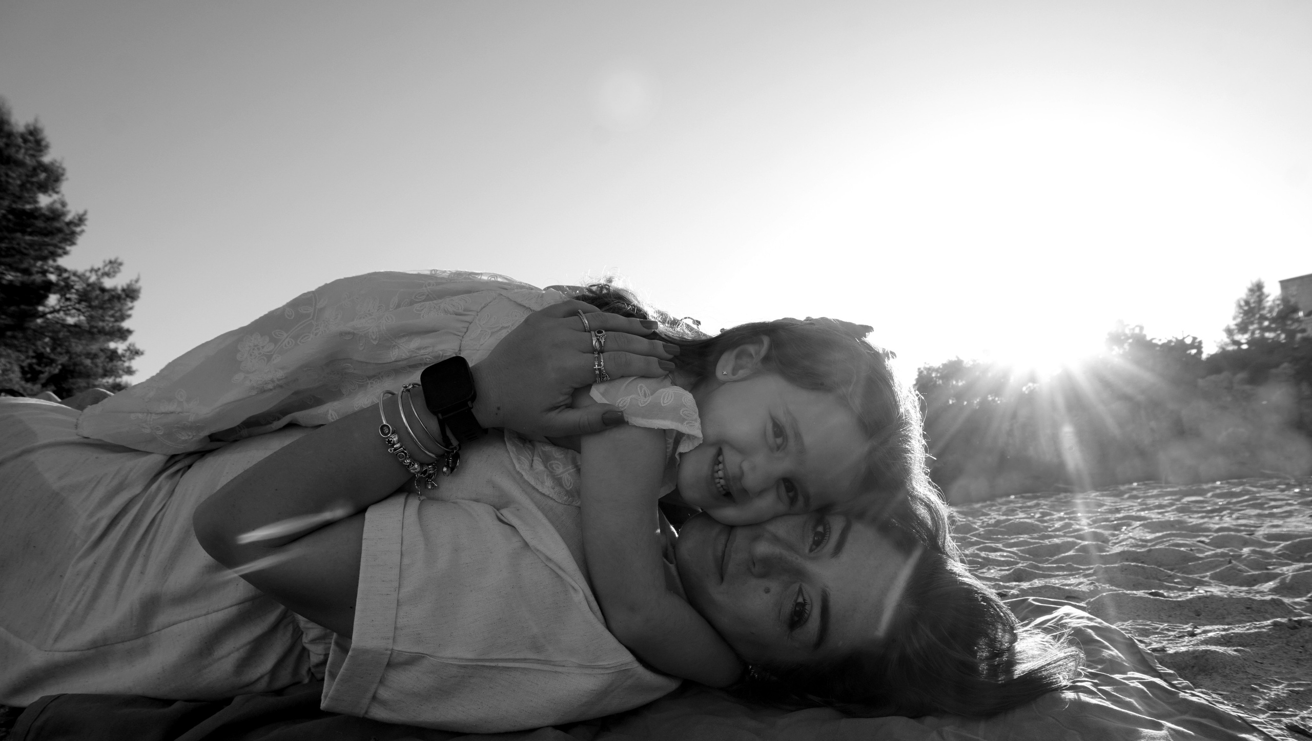 Genitori che abbracciano il loro bambino sulla sabbia calda con vista sulle scogliere.