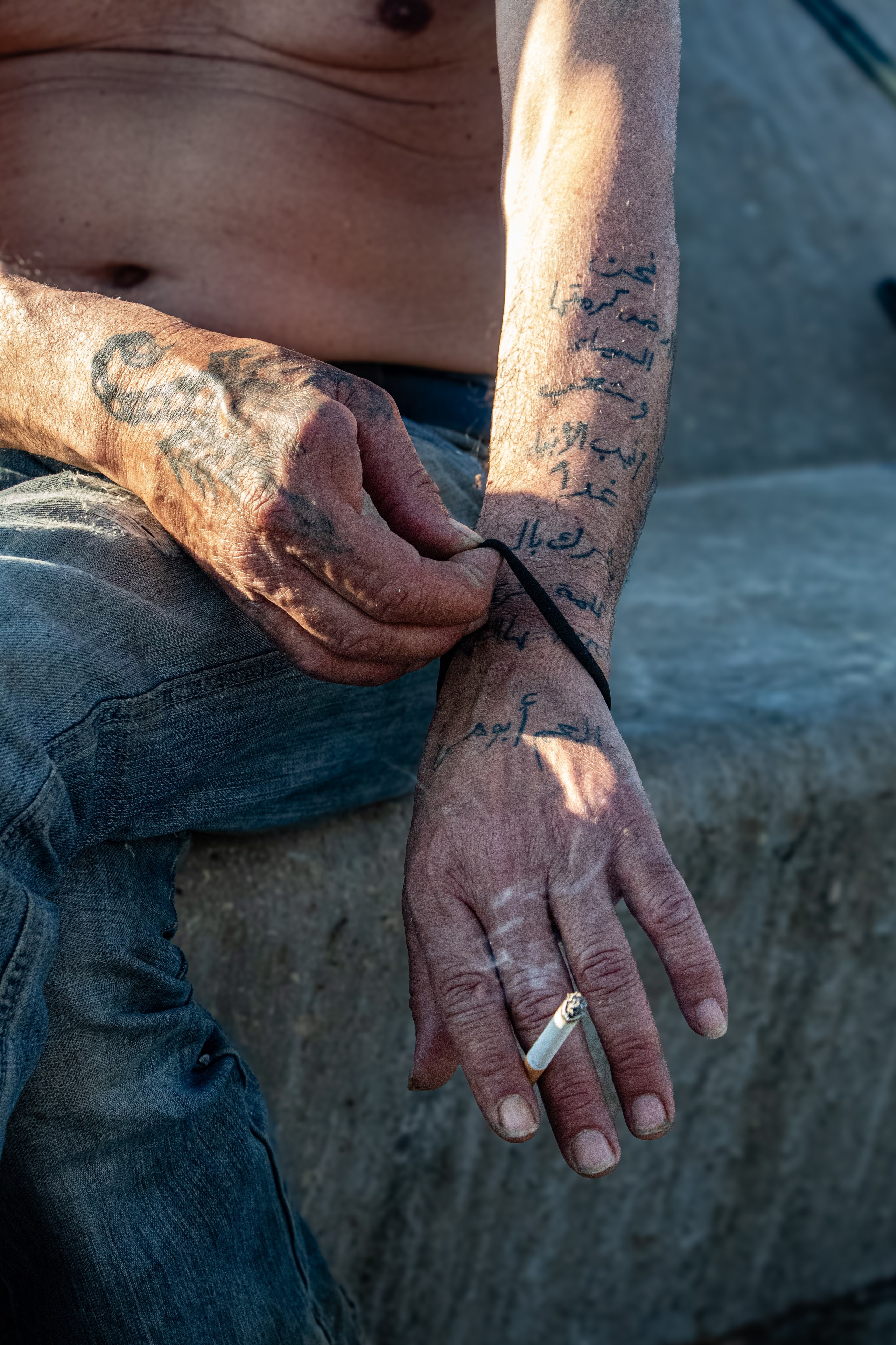 Les mains et avant-bras tatoués d’un pêcheur sur le port de Beyrouth, juste avant de traverser la frontière vers la Syrie.