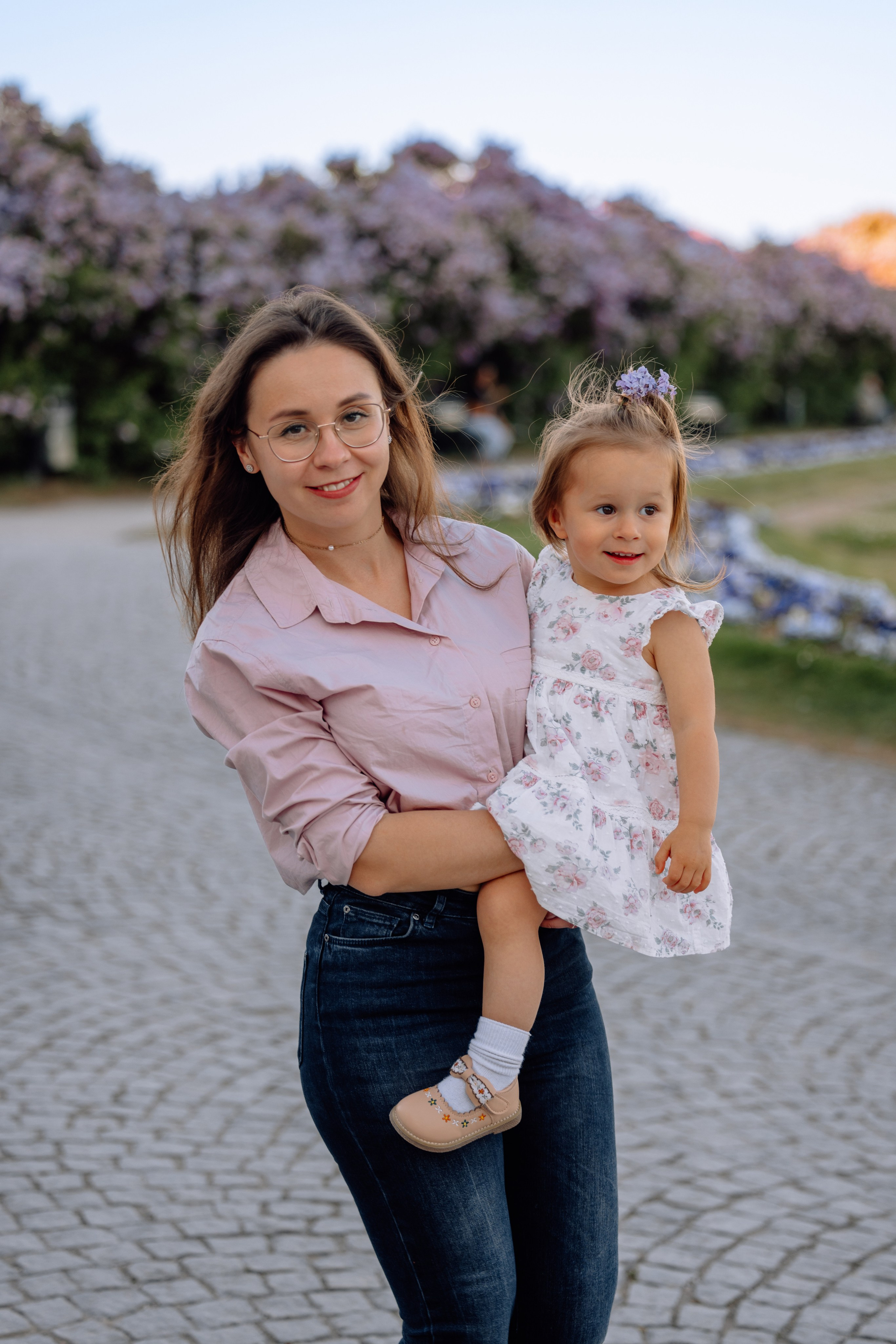 Papa hält Tochter auf dem Arm und umarmt Mama beim Familienfotoshooting in München