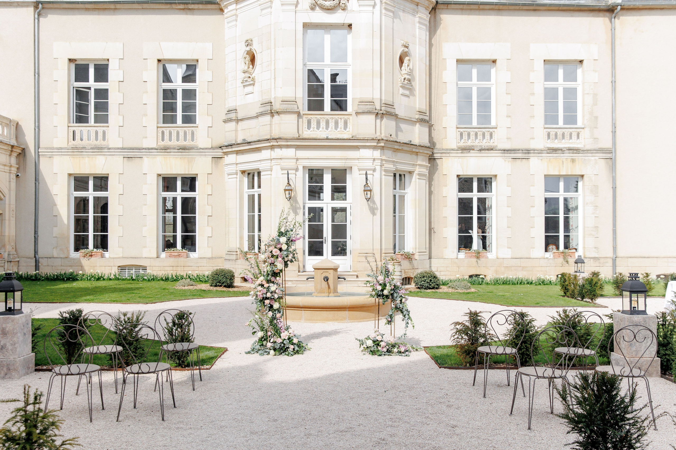 Ceremony setup at a historic wedding chateau in France, showcasing charming architecture and floral arrangements