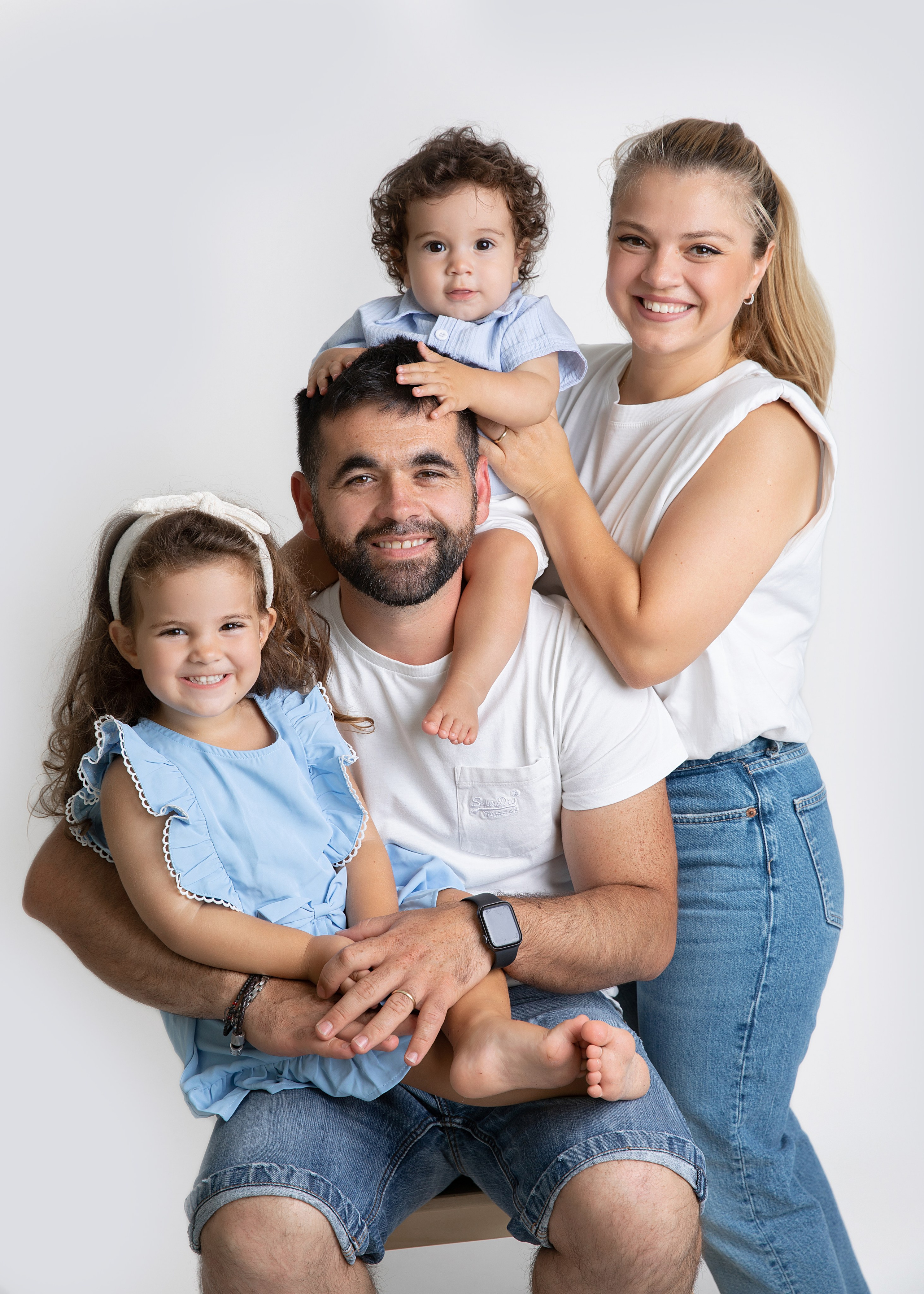 Mamma, pappa och barn tillsammans i en minnesvärd familjefotografering i vår fotostudio.