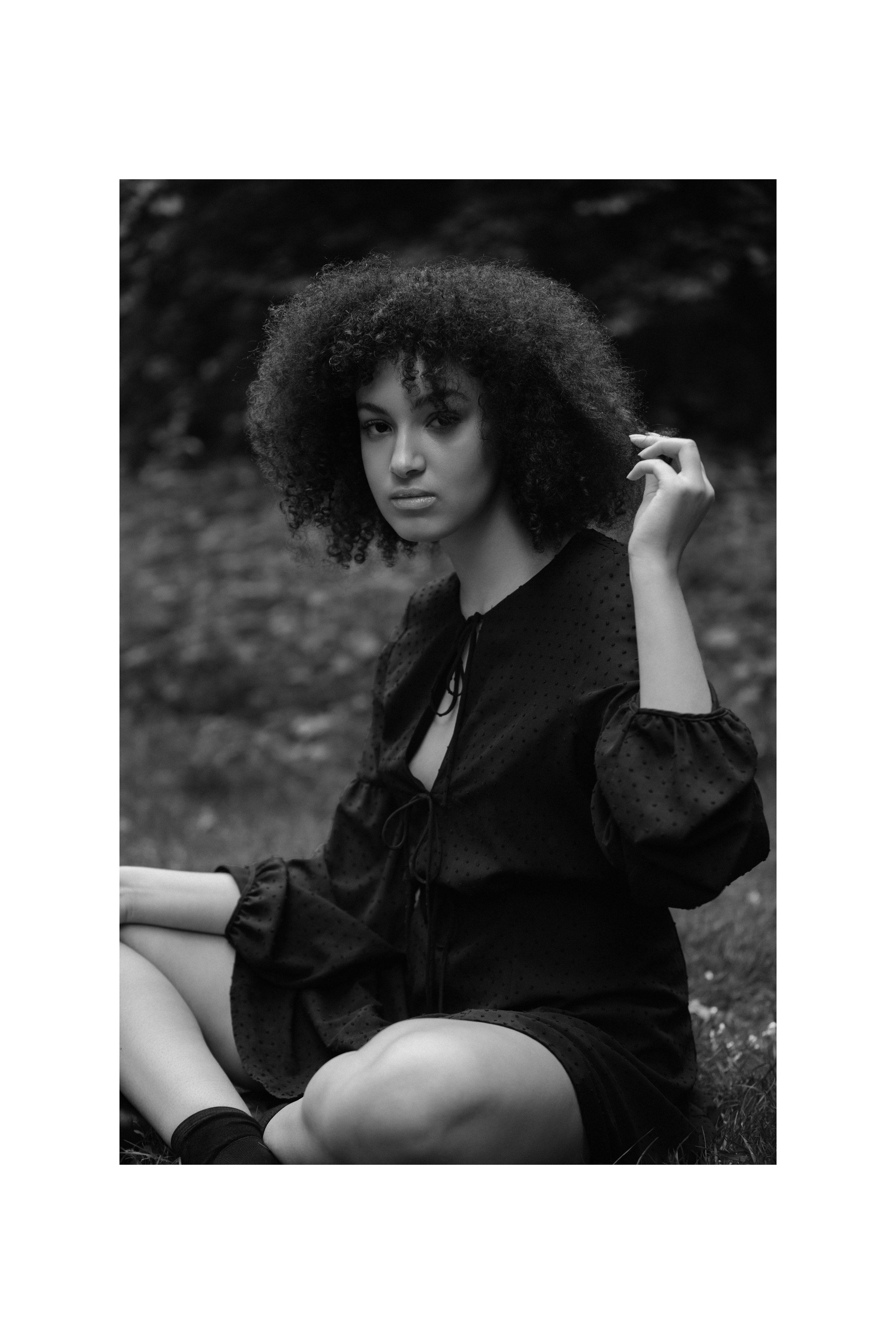 Black and white portrait, woman touching hair, seated pose