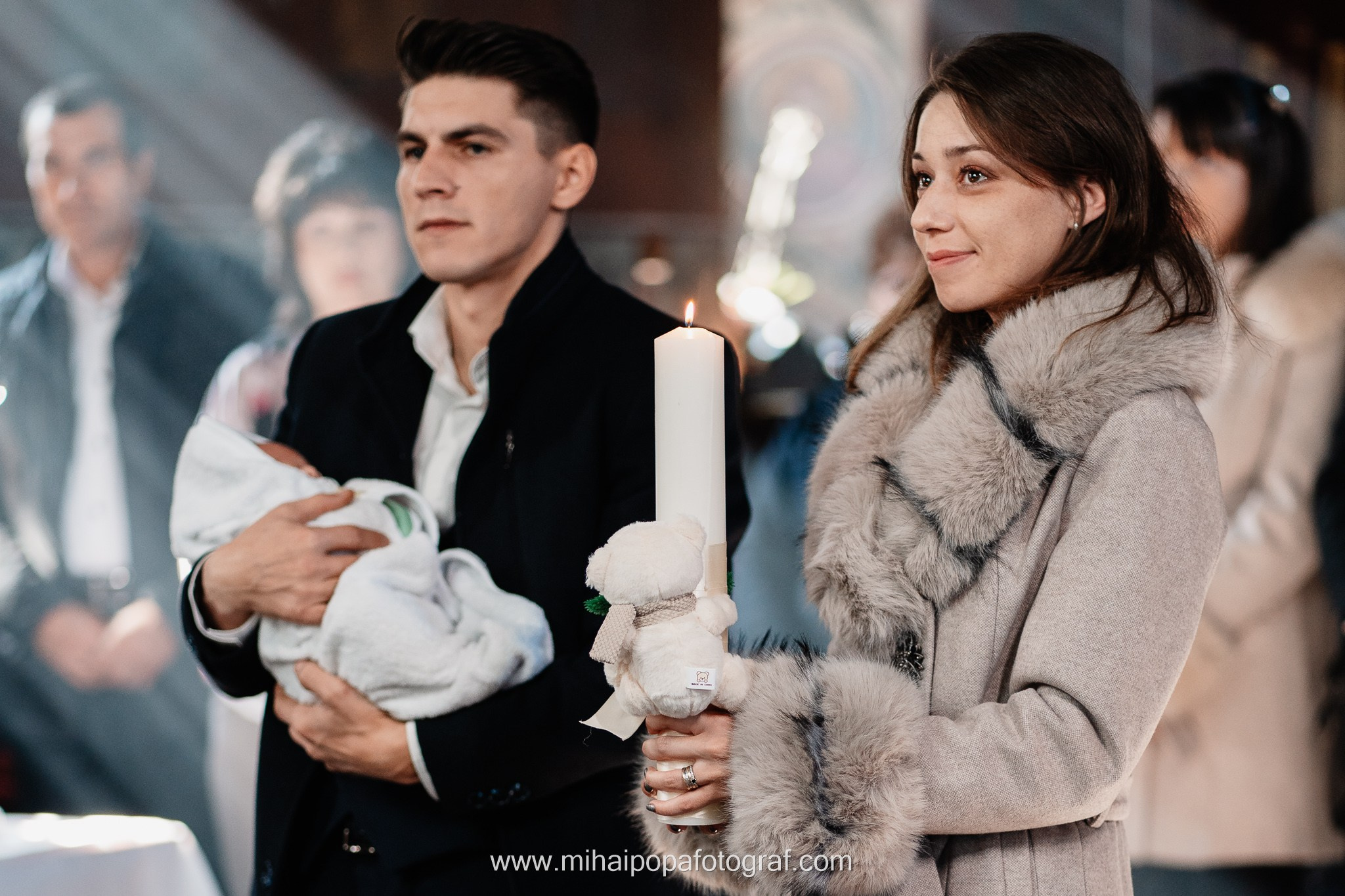 Instantaneu plin de tandrețe dintre părinți și bebeluș în ziua botezului, realizat în ilfov. Fotografie profesională de botez, capturând emoțiile autentice ale familiei într-un decor luminos și cald