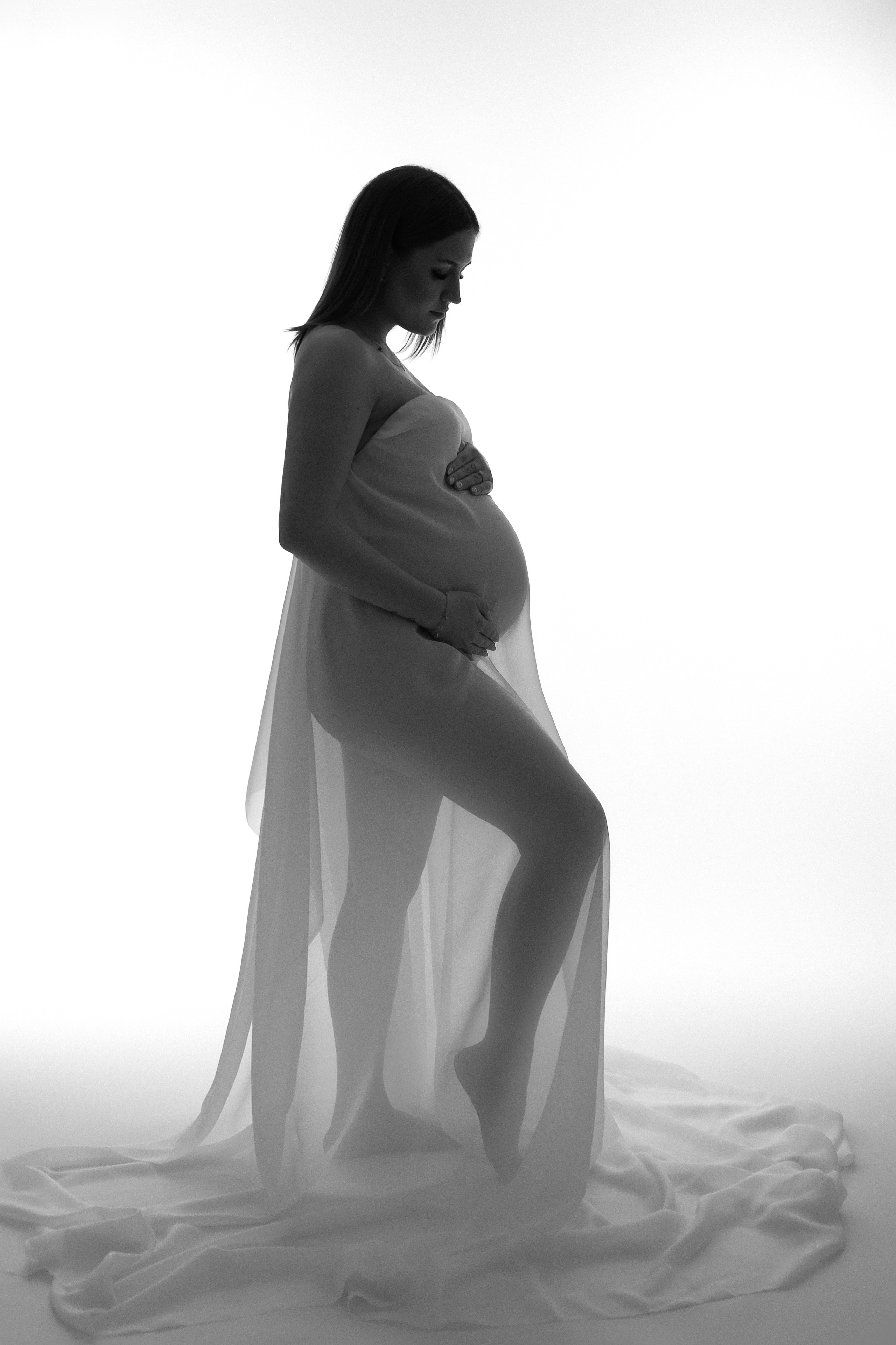 Schwangere Frau in weißem Tuch – natürliche Schönheit der Schwangerschaft