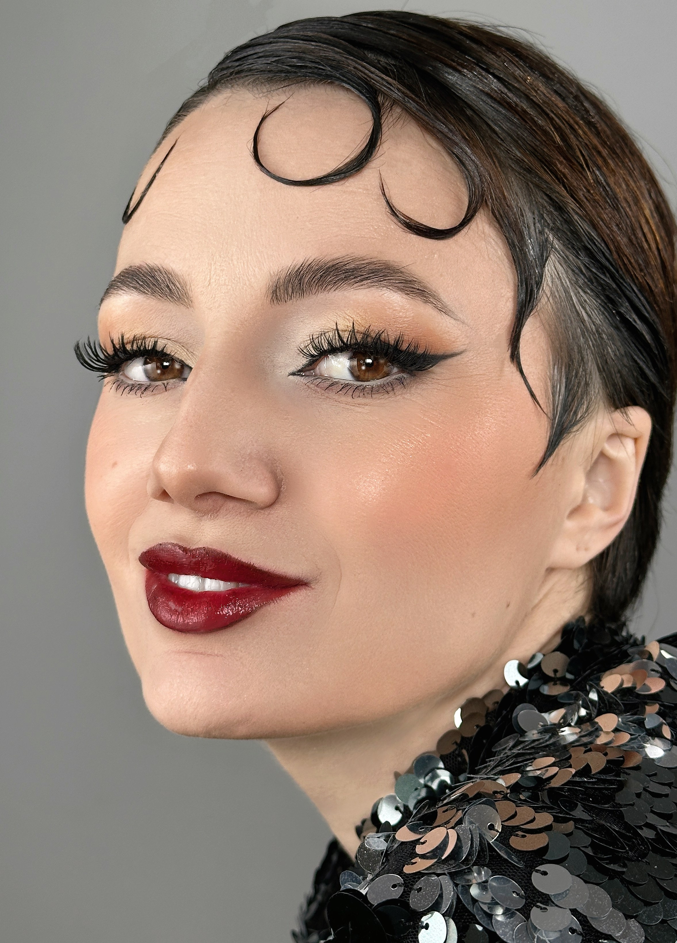 „Machiaj retro glam iconic inspirat din anii '50, cu eyeliner cat-eye, buze roșii intense și ten impecabil. Un look clasic și elegant pentru evenimente speciale.”