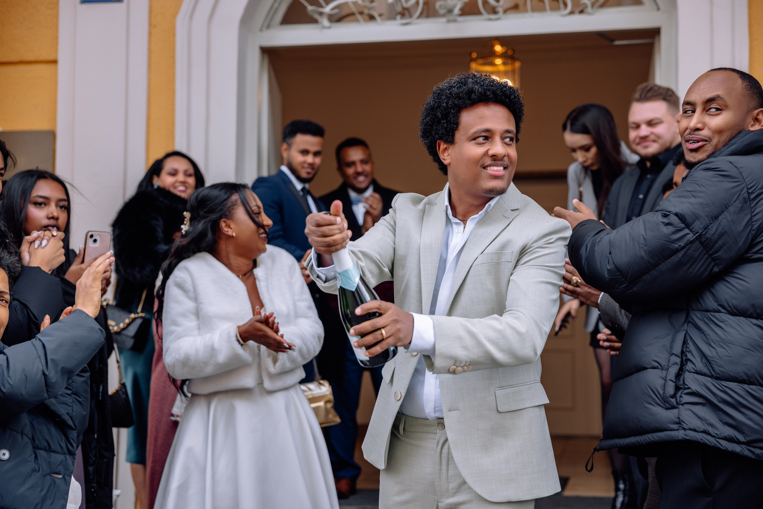 Bräutigam öffnet Champagnerflasche – Gäste feiern vor Standesamt Schwabing