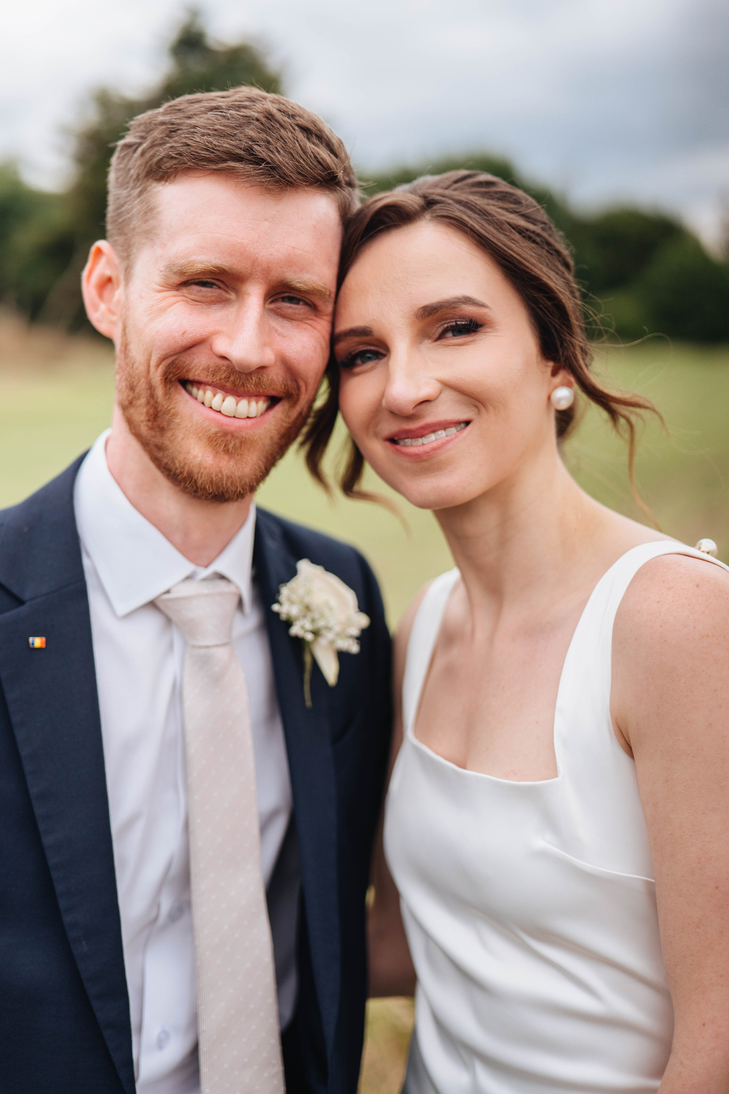 moody photo of bride and groom smiling at the camera