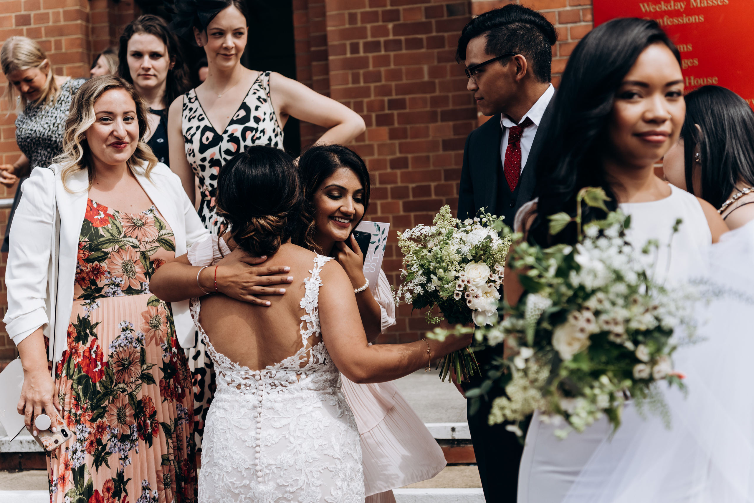 bride is hugging with guests after wedding ceremony 