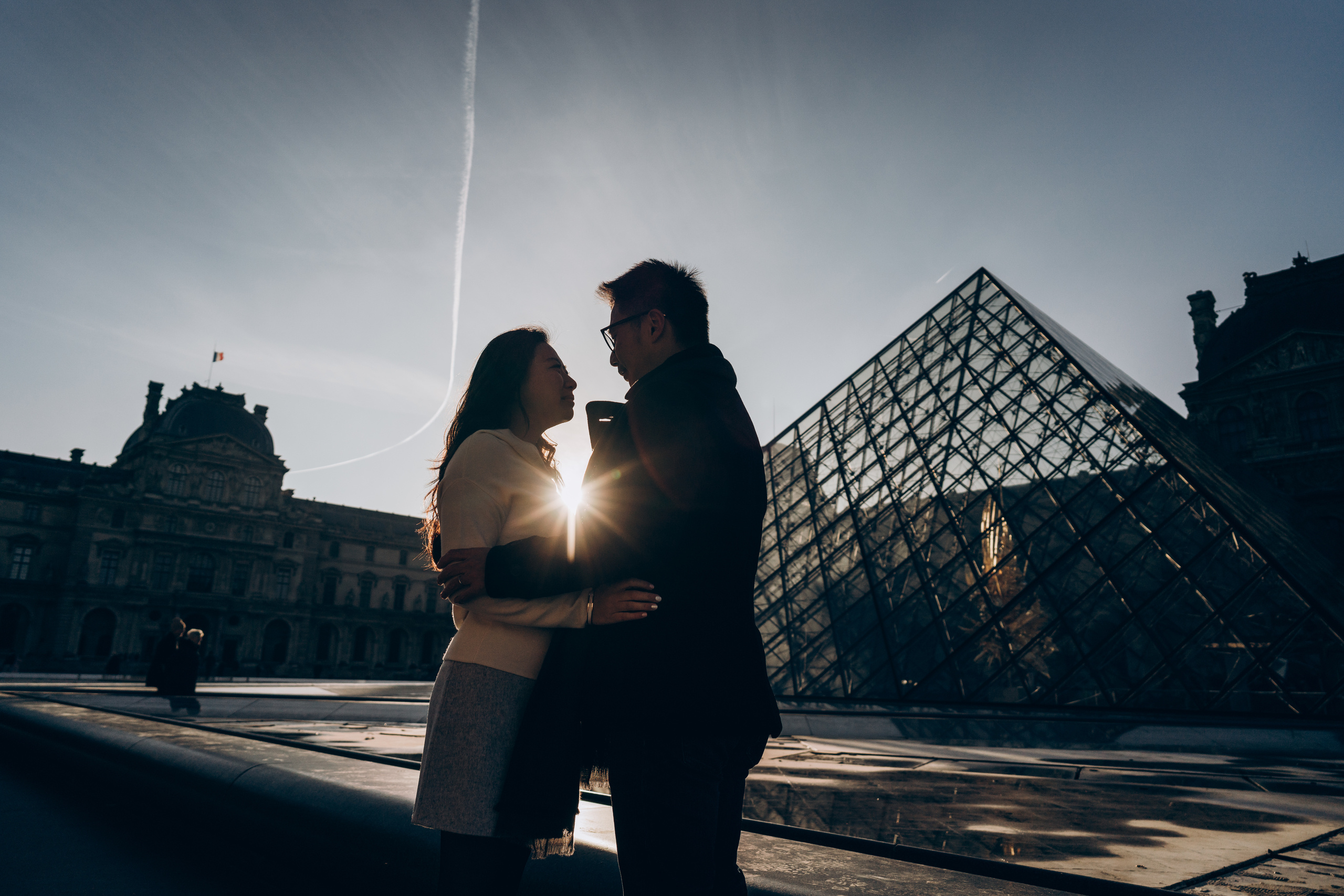 couple salute at front of Louvre 