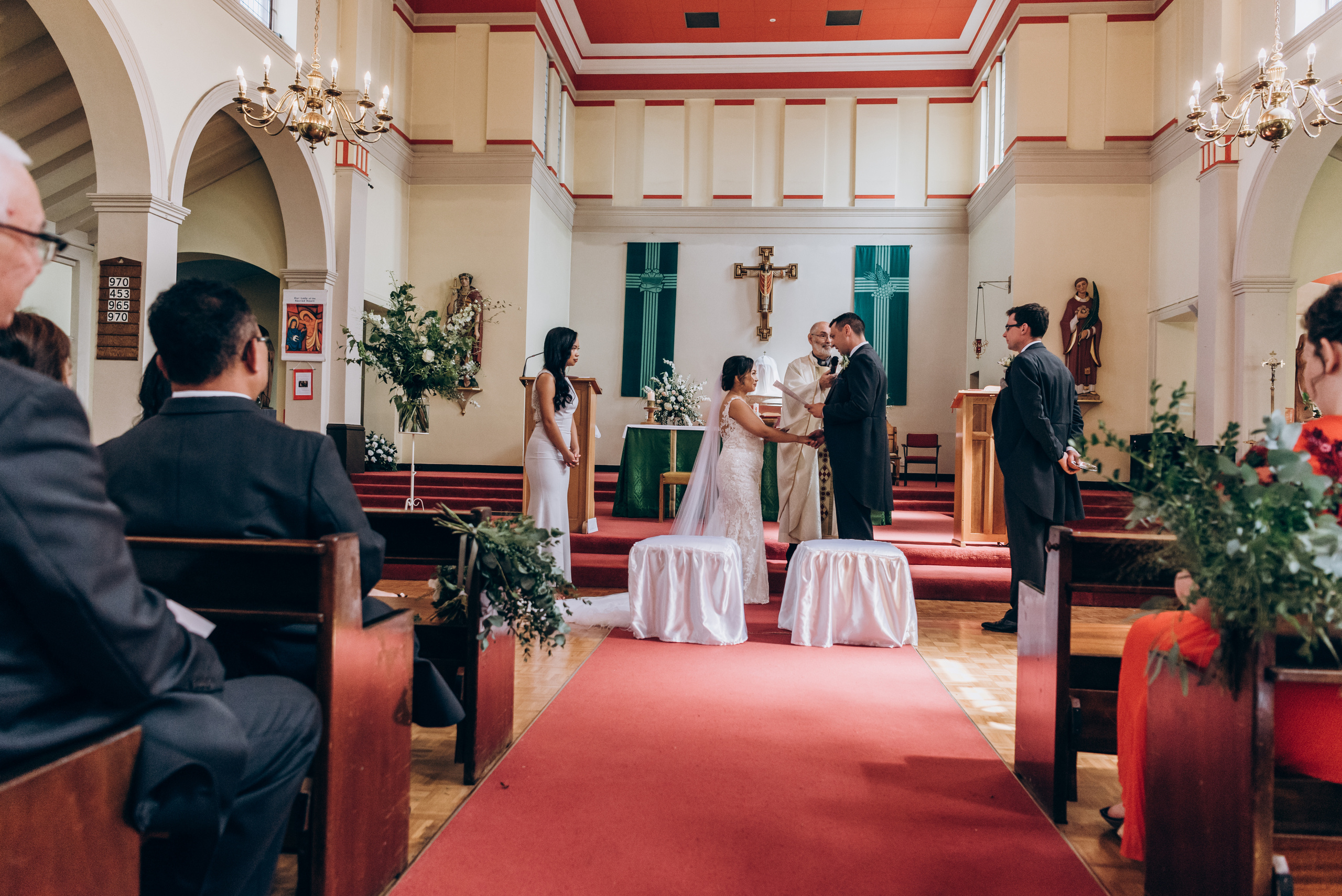 wedding ceremony in church, bride and groom standing by altar 