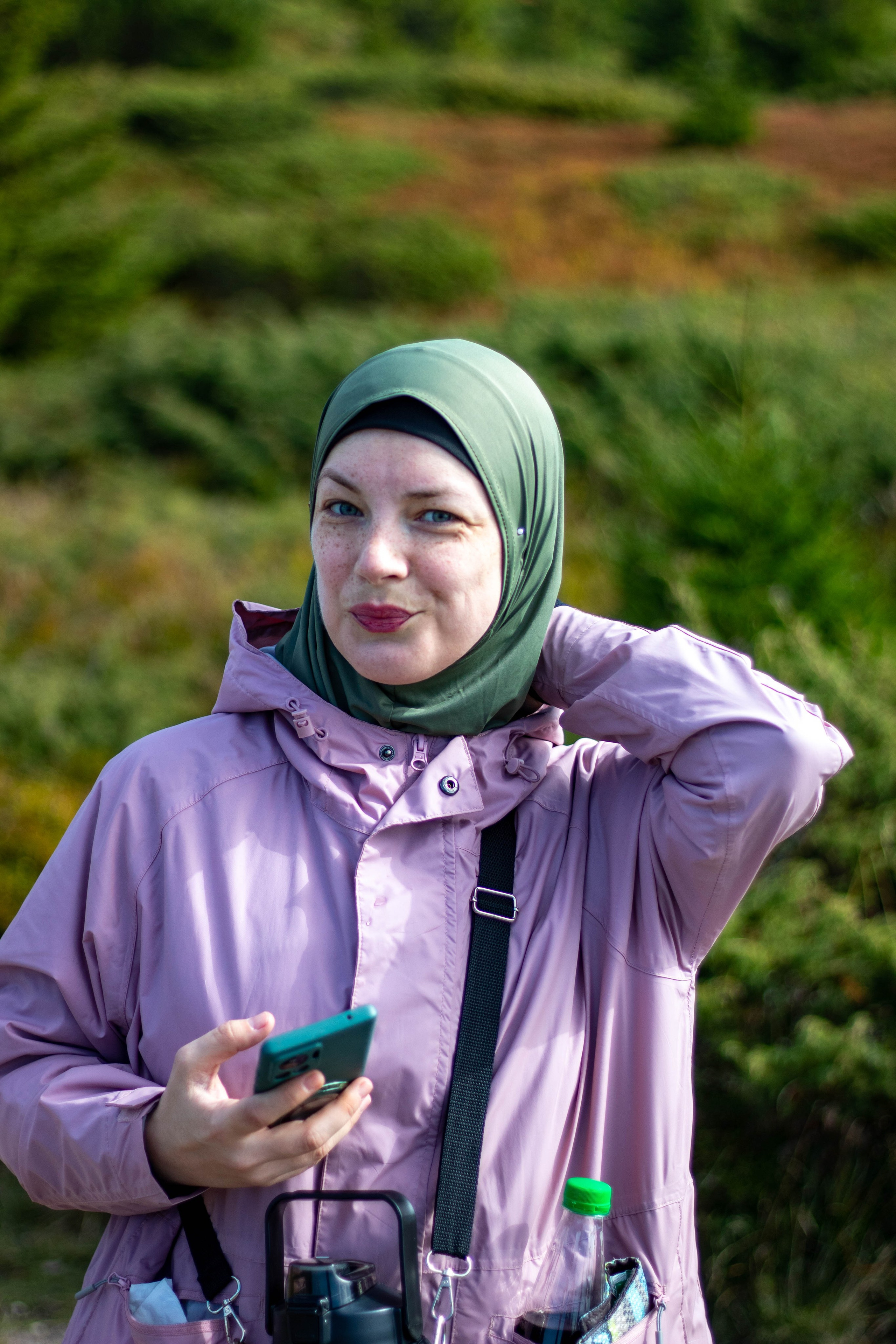 Portrait of a person dressed in camouflage, crouching in a forest setting with focused body language.