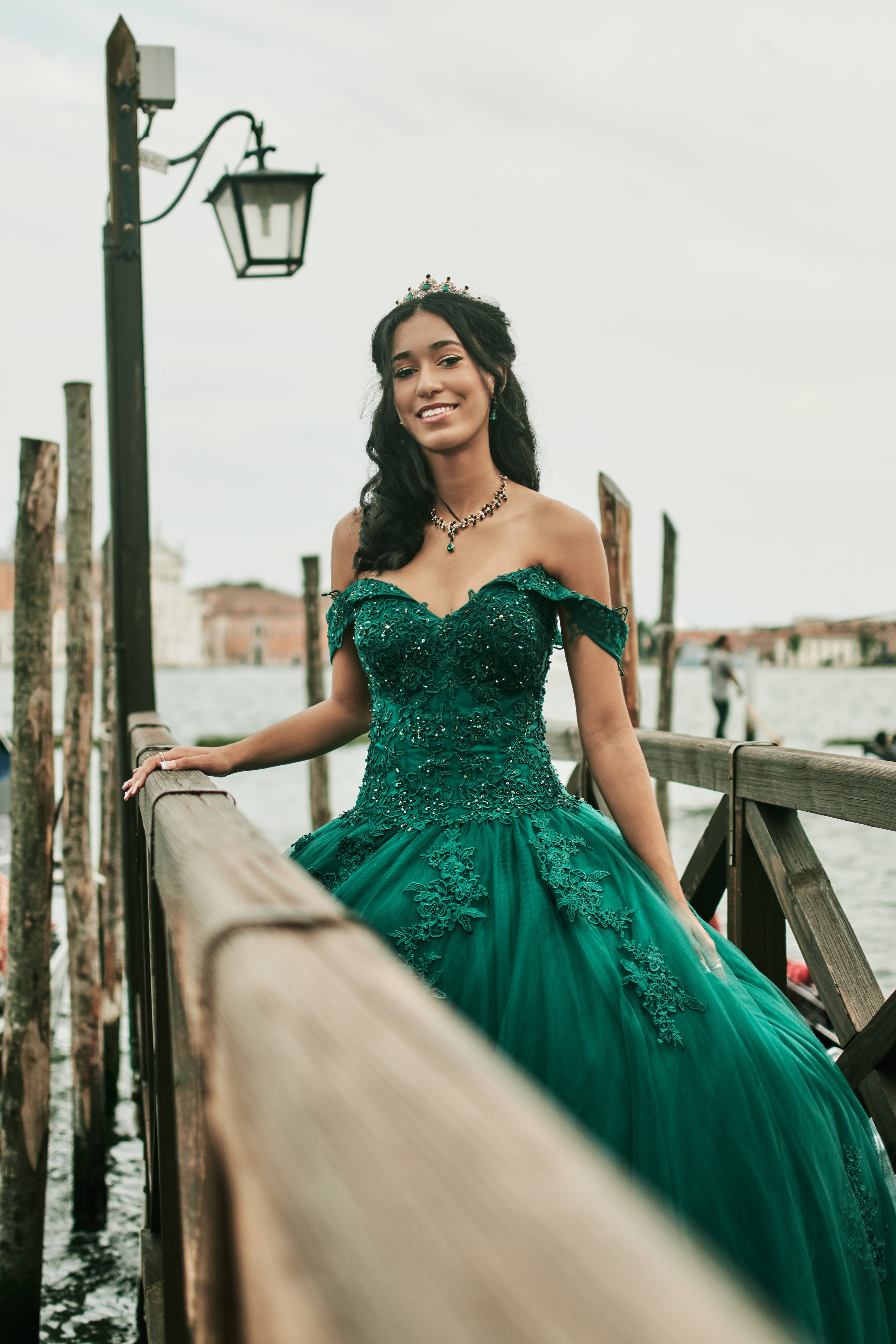 Timeless beauty: Quinceañera gracing St. Mark's Square in a Venetian quinceanera photoshoot. Captivating portrait of a young lady wearing a striking green dress.