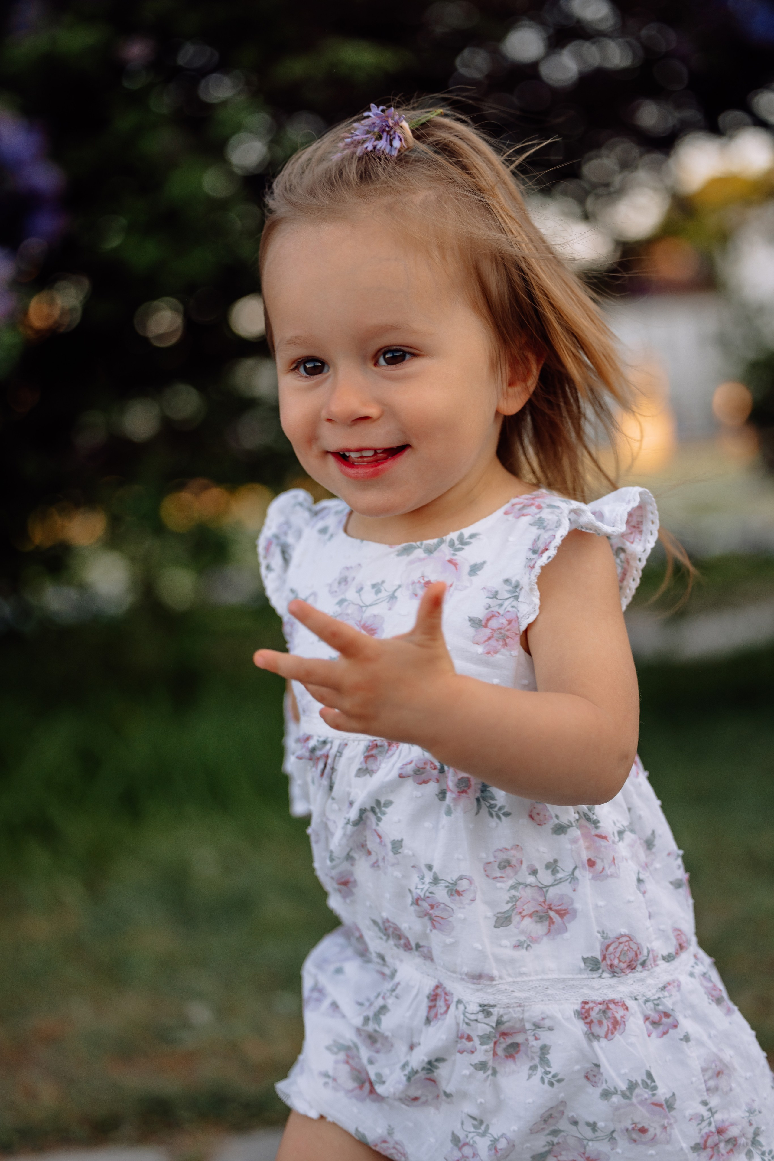 Kleine Tochter läuft lachend durch den Park beim Schloss Nymphenburg