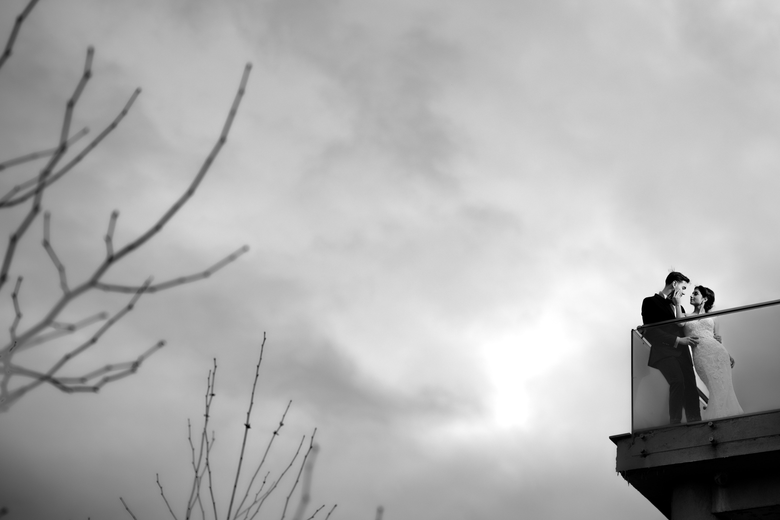 Mire și mireasă pe balcon, în zi mohorâtă, imagine alb-negru emoțională