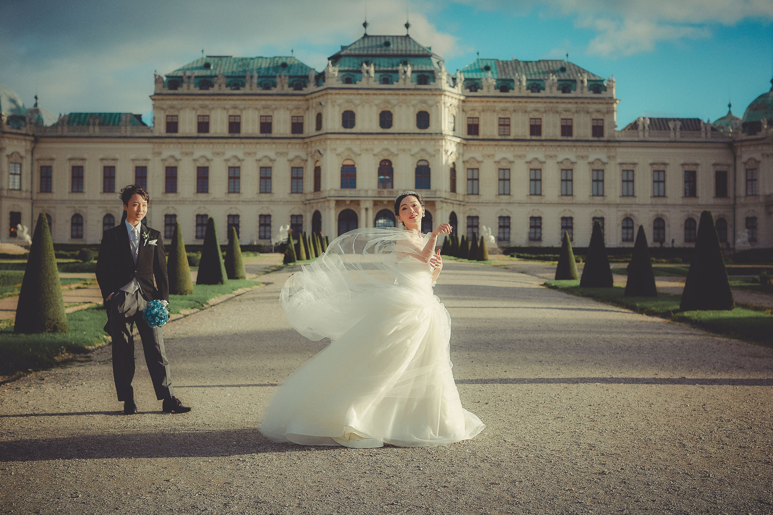 The beautiful bride plays with her veil as a gust of wind picks up on the grounds of the Belvedere Palace.
