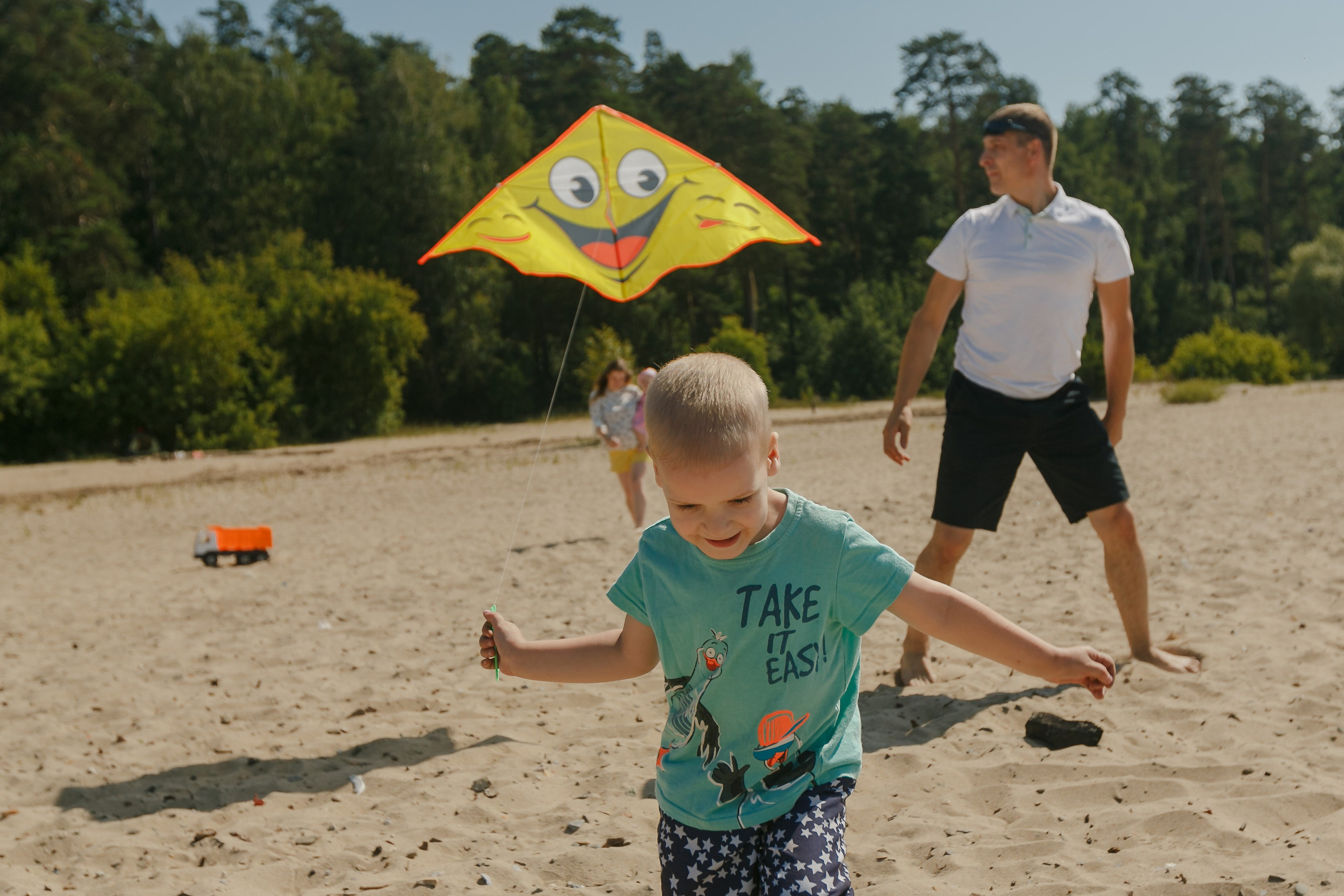 padre e hijo vuelan una cometa a la playa del mar