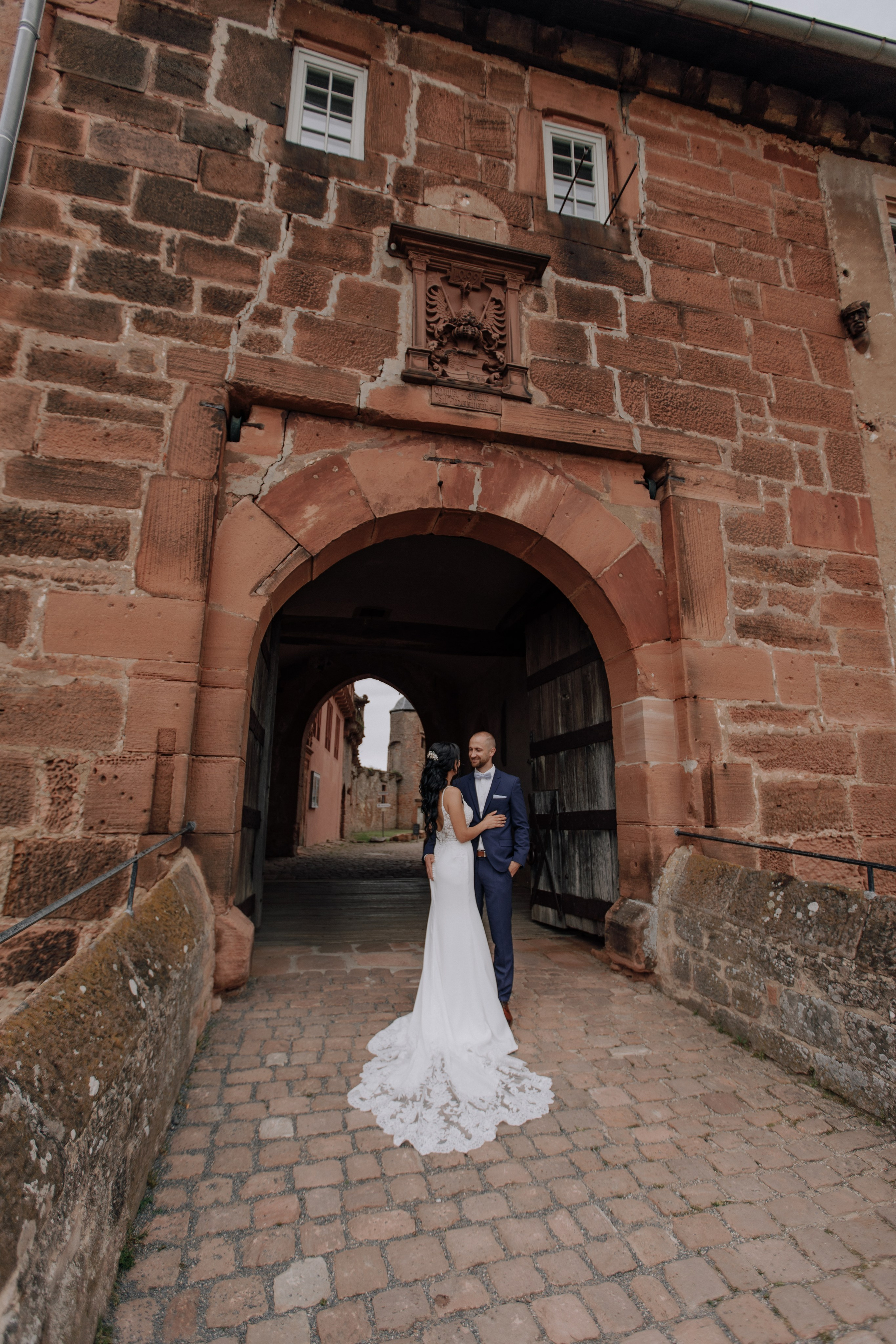 Bräutigam und Braut stehen vor Burg Breuberg.
