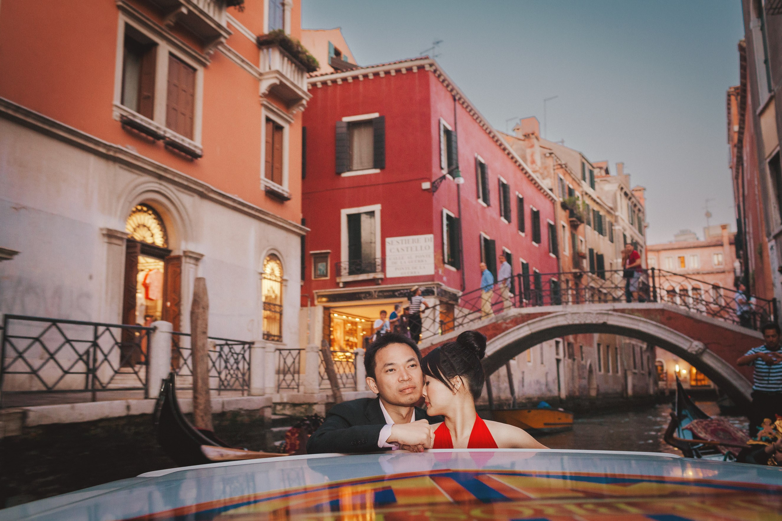A young Thai couple explores the historical canals of  Venice at Dusk in a private boat.