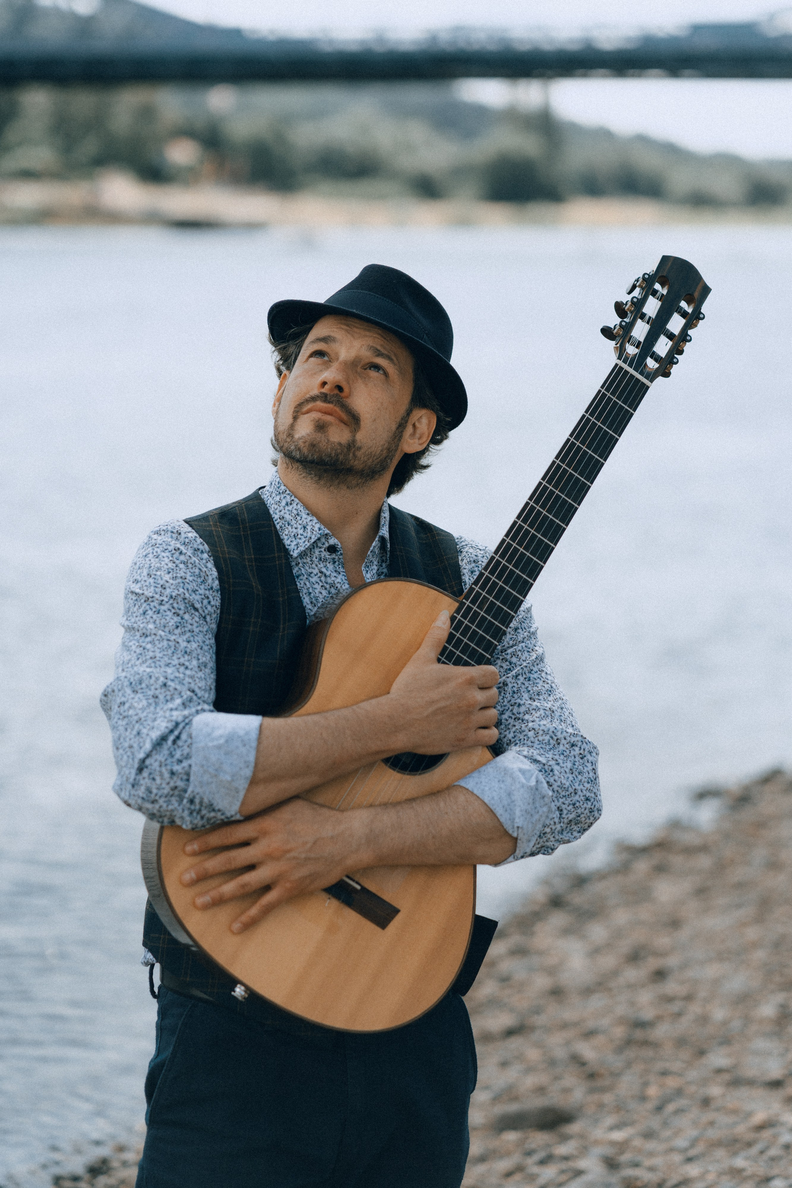Portrait eines Gitarristen mit Instrument an der Elbe