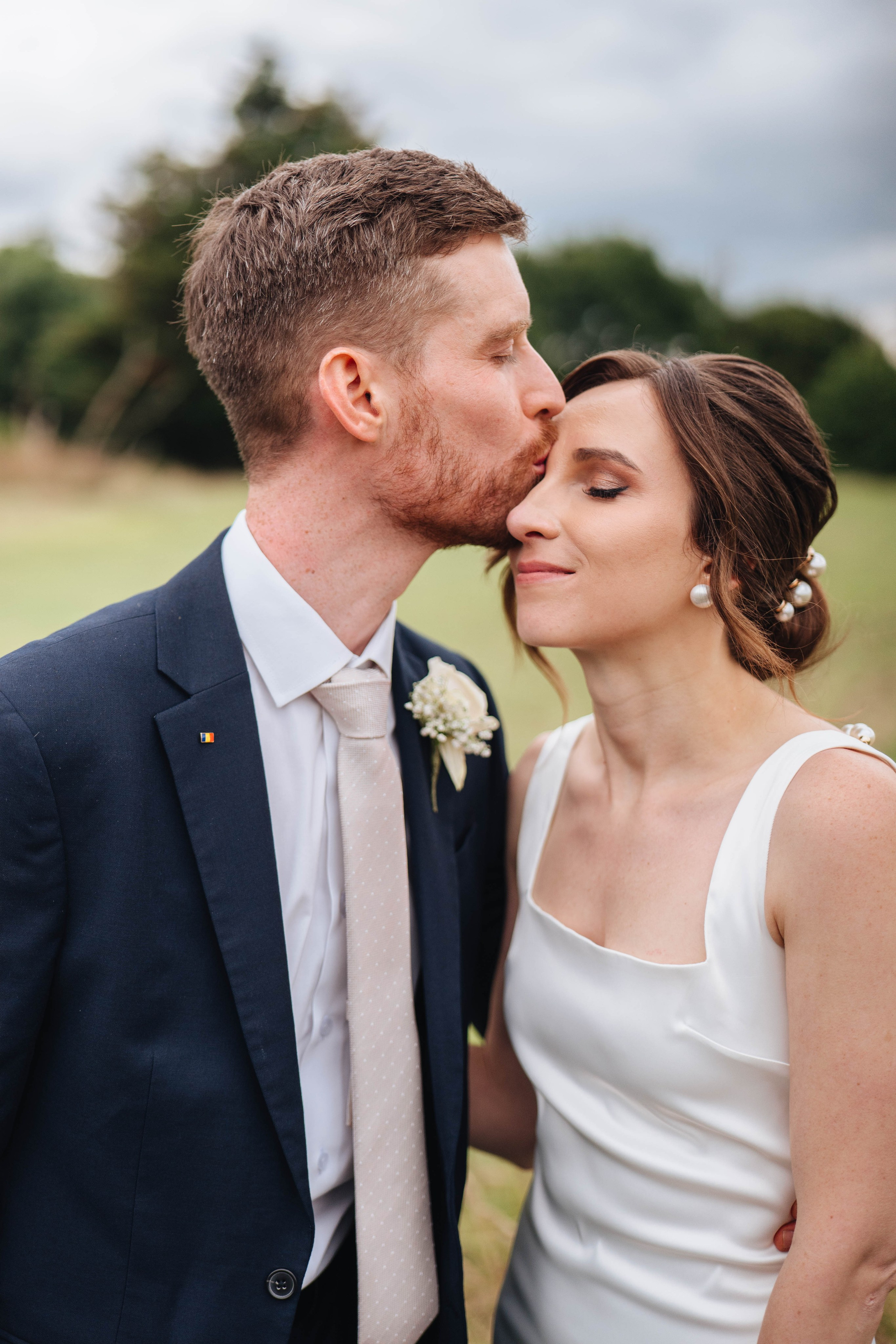 moody photo of groom kissing the bride in the face