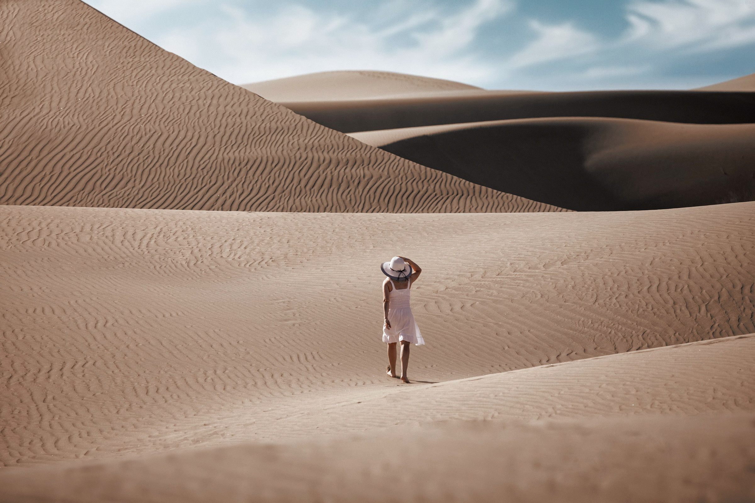 A woman is standing in the middle of a sand dune. Desert Maspalomas Gran Canaria Photographer
