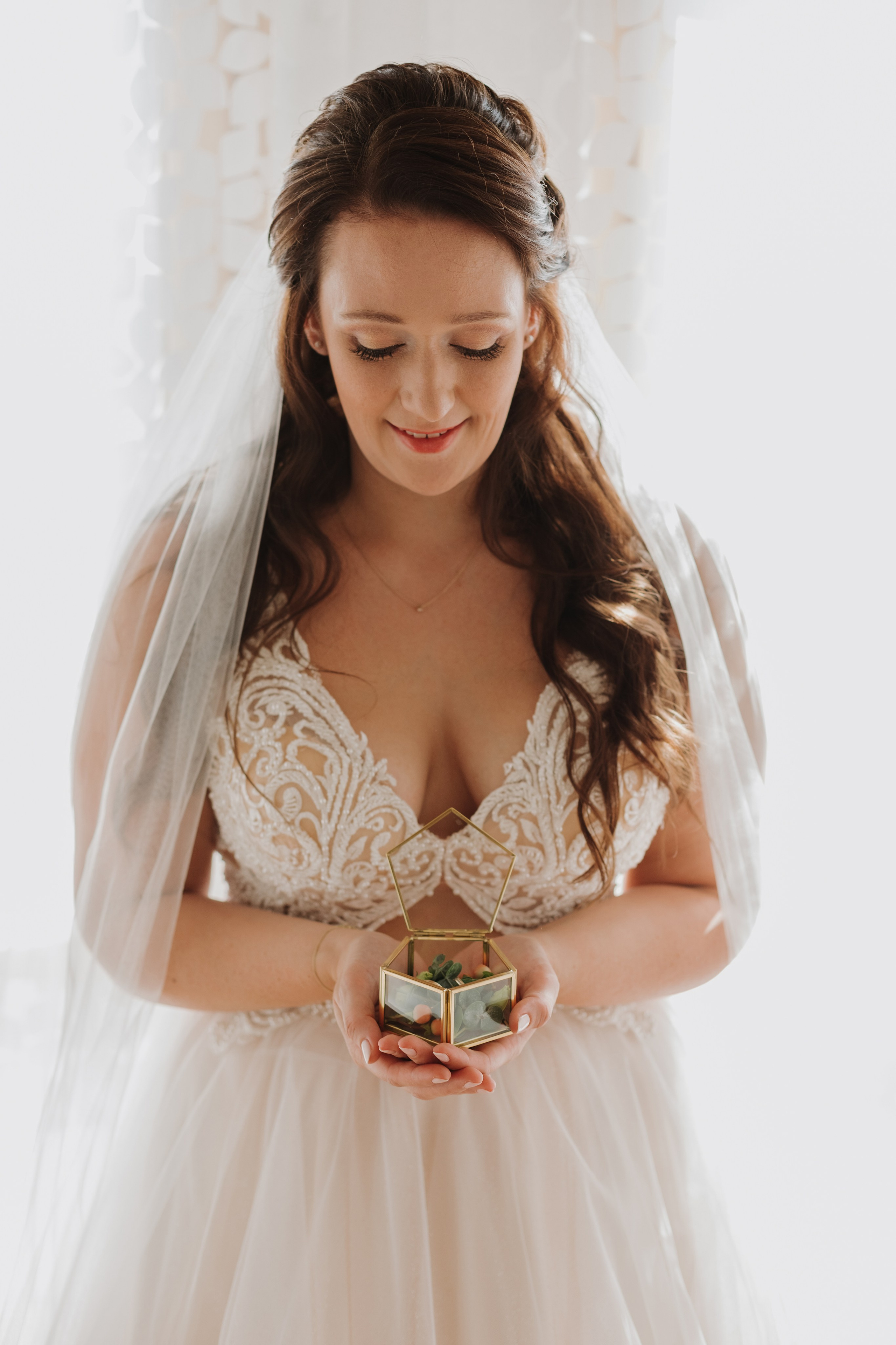 Die Braut blickt liebevoll auf die Ringschatulle.