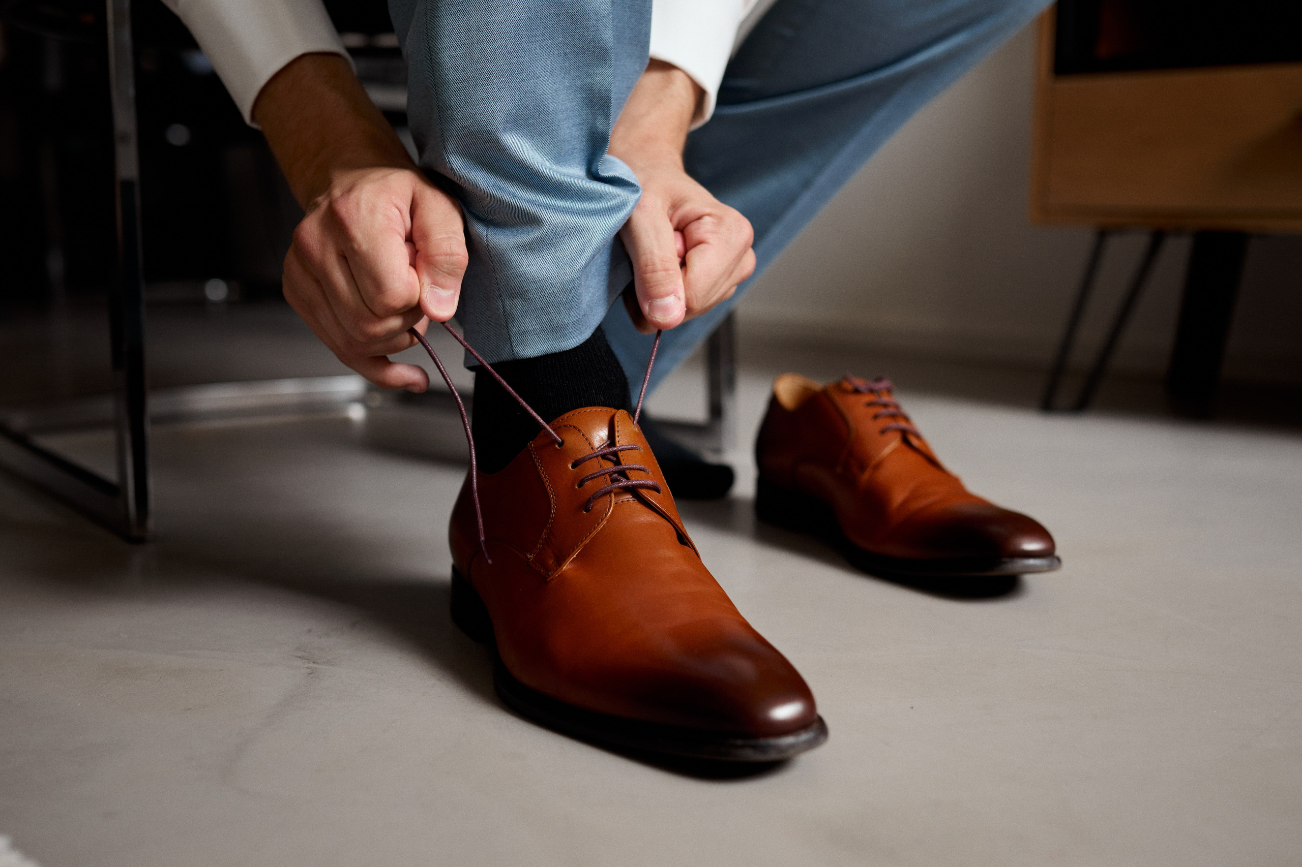 Nils bereitet sich auf die kirchliche Trauung vor – konzentrierter Getting-Ready-Moment beim Schnüren seiner Schuhe, festgehalten vor der Feier im Schloss Meßkirch.