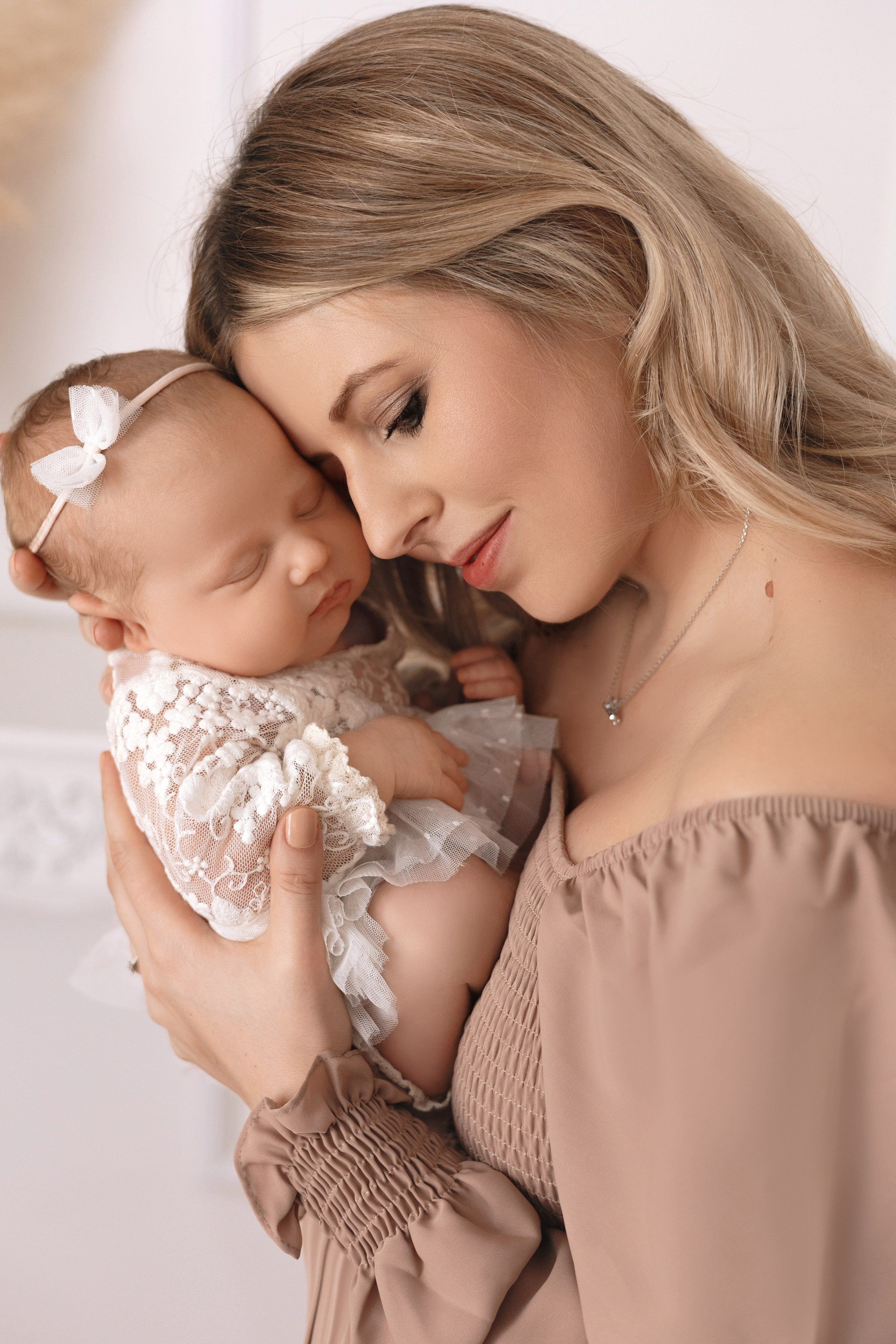 Emotionale Aufnahme einer Mutter, die ihr Neugeborenes liebevoll küsst – Babyfotoshooting in Iserlohn.