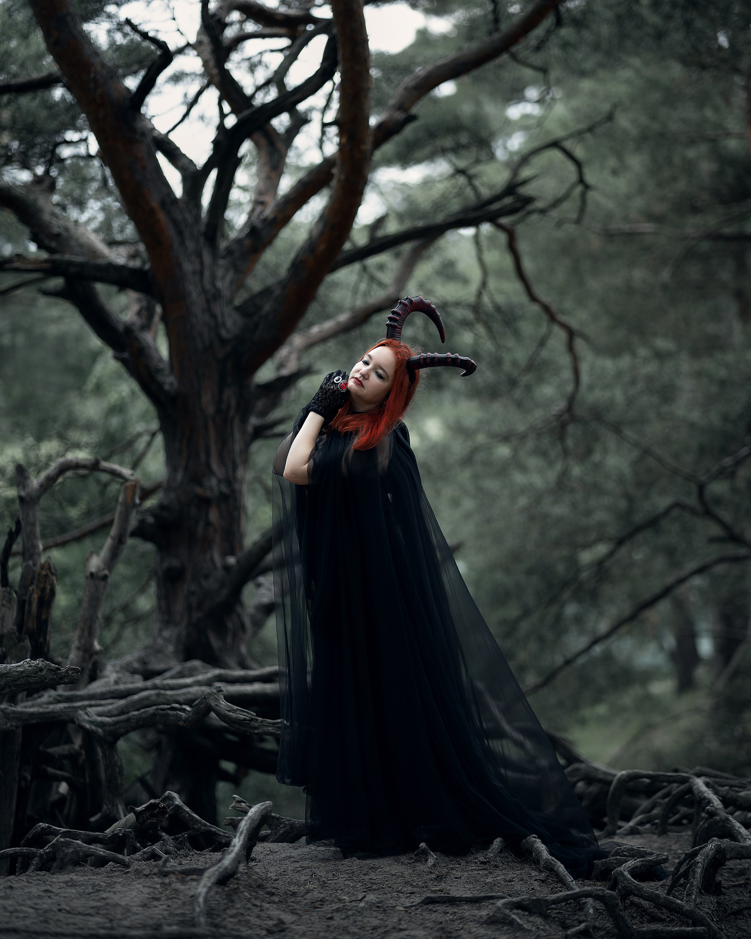 Dunkle Ästhetik im Wald: Ksenia im dämonischen Look mit Umhang und Hörnern