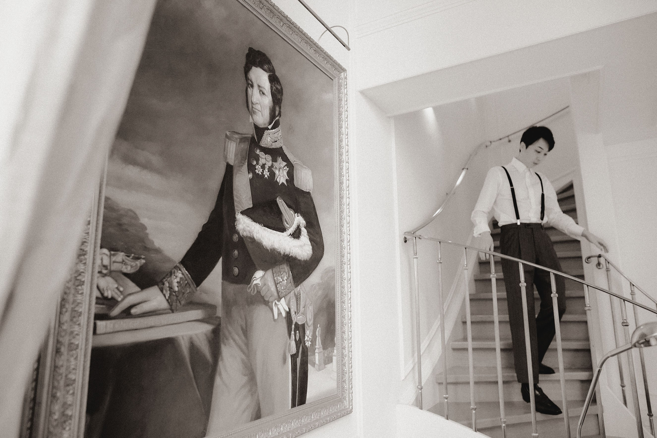 The groom near a historic painting in his luxury suite.