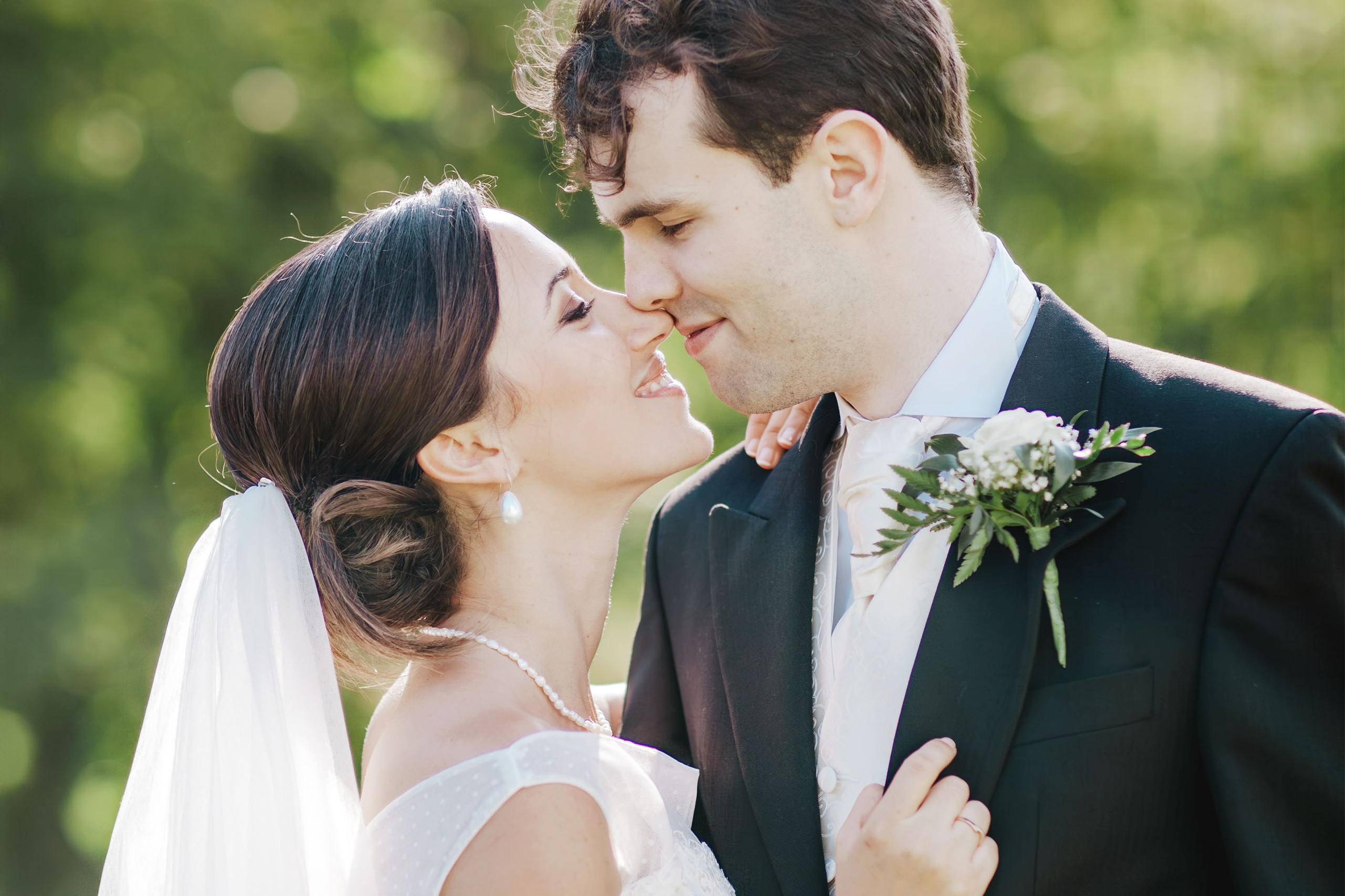 An Israeli bride and her English groom enjoy the warmth of the summer sun during their portrait session on the grounds of a chateau in Bohemia.