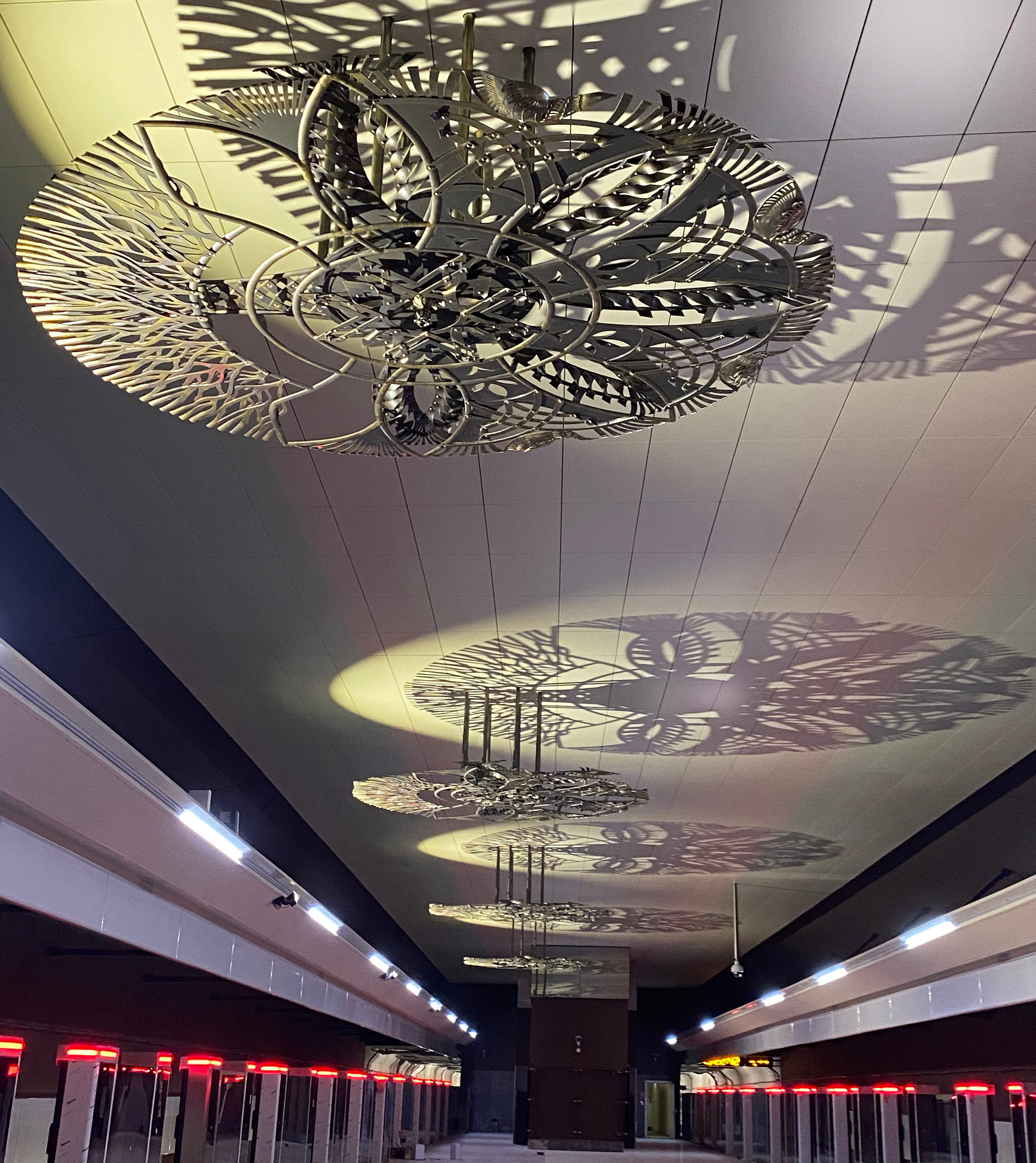 Минское Метро. Станция «Ковальская слобода». 2019-2020 «КАВАЛЬСКIЯ ВЫЦIНАНКI» кованые подвесные светотеневые композиции, декоративные элементы. Сталь, художественная ковка, лазерная резка, сварка. Художники Мария Тарлецкая, Павел Войницкий, Архитекторы Владимир Телепнёв, Ольга Телепнёва, Анна Кузмич. По мотивам произведений Елизаветы Червонцевой и Молодечненской школы вытинанки. Перонн. Перонный зал.