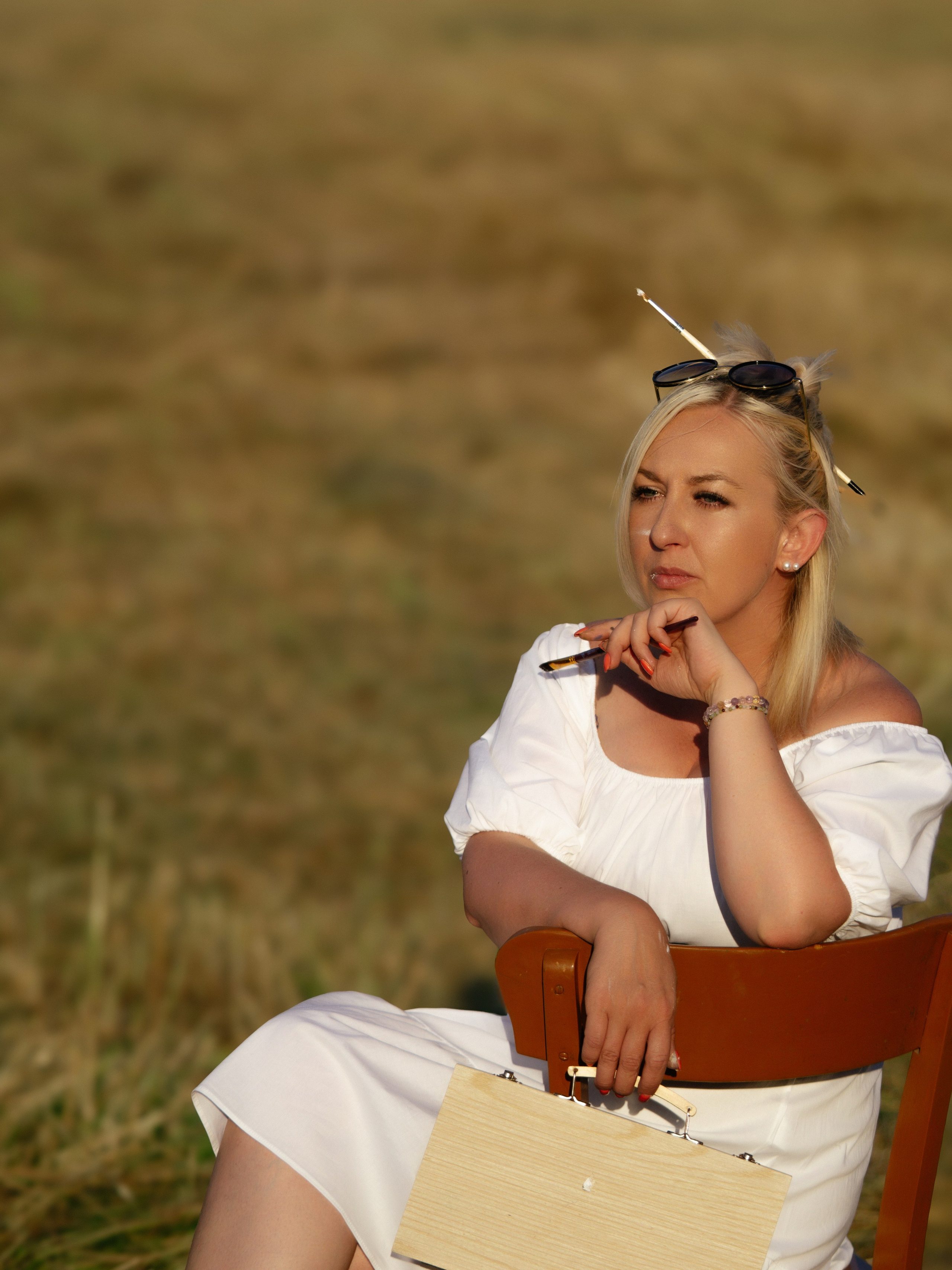 Kreative Frau in der Natur, die mit Pinsel in der Hand eine Idee überlegt